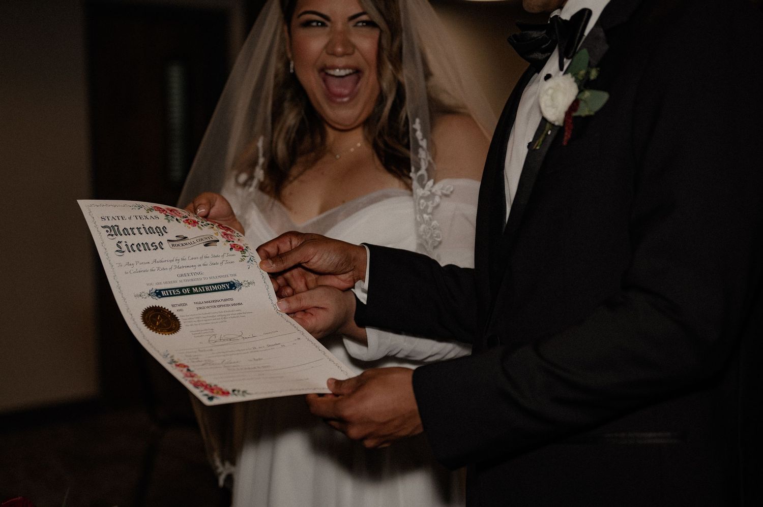 Bride enthusiastically celebrating the signed marriage license with her new husband at the wedding reception