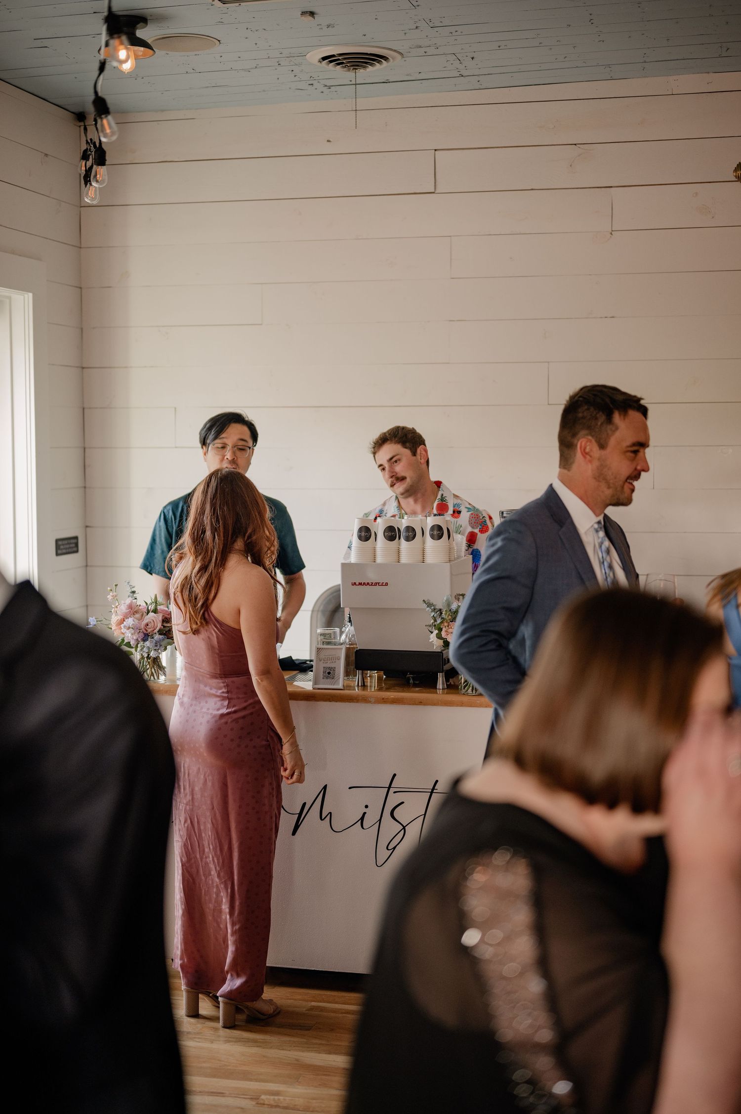 Guests mingle in a vintage venue with paneled walls during a wedding reception