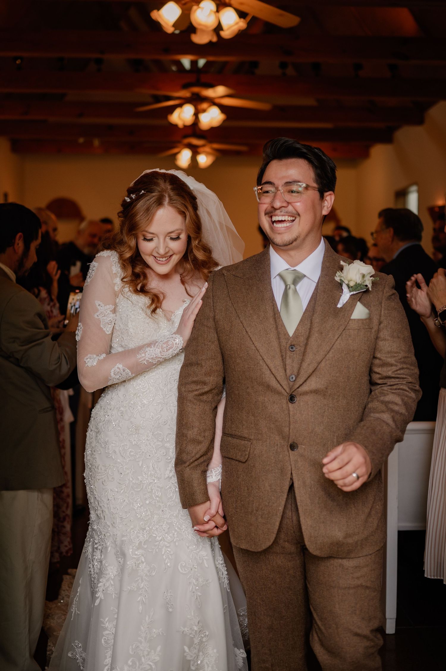 Joyful close-up candid photo of Bride and Groom exiting an indoor Spring wedding ceremony in Rockwall, Texas