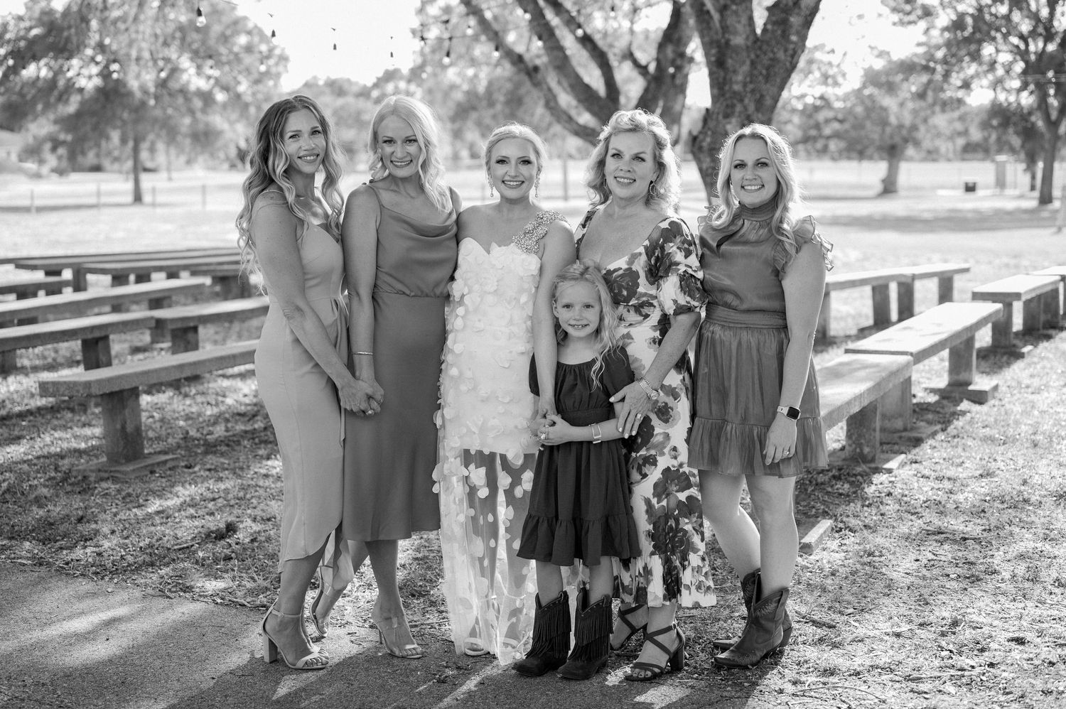 Black & white photo of a bride with her mom, siblings, and niece during family wedding portraits.