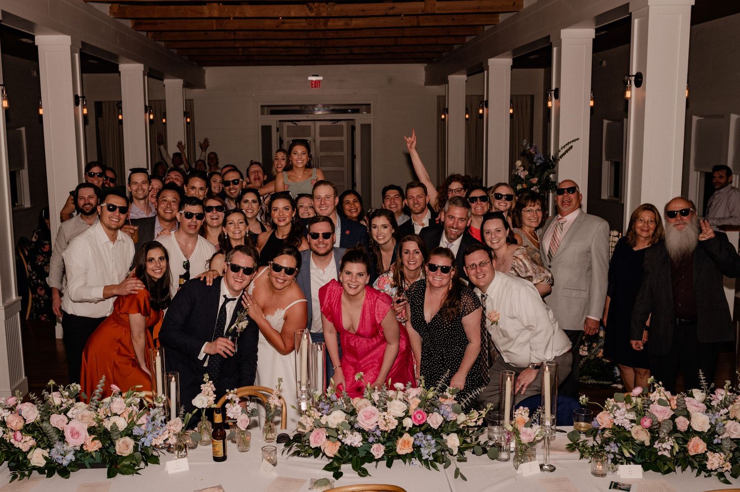 Large group photo of wedding guests gathered at lively reception in Bishop Arts venue in Dallas, Texas