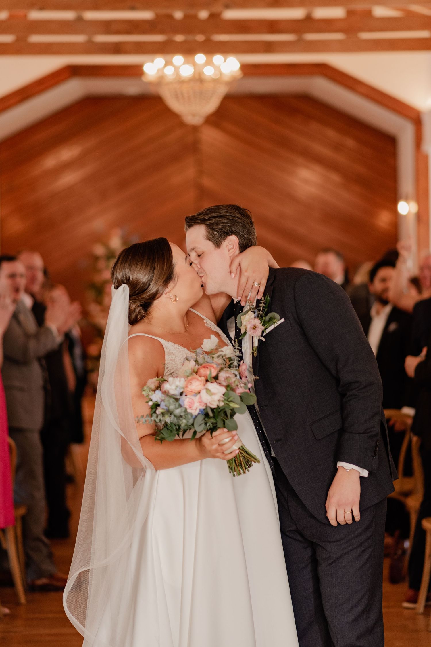 Romantic wedding moment of bride and groom kissing as they exit their wedding ceremony at Bishop Arts venue in Dallas, Texas