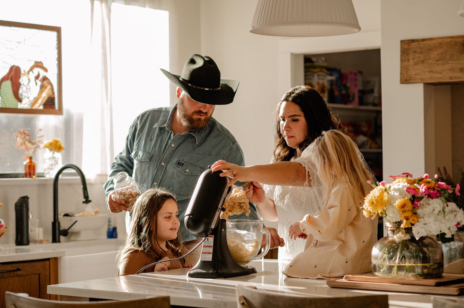 Documentary photo of a family 4 in a large bright kitchen making cookies for a documentary at-home family photo session