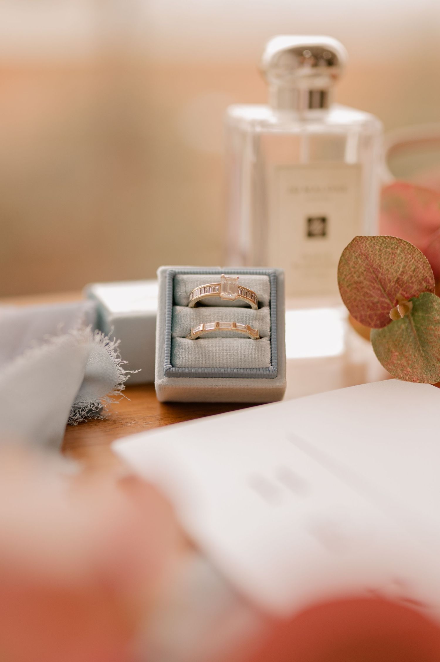 Close-up of delicate vintage-style ring boxes arranged on soft white surface.