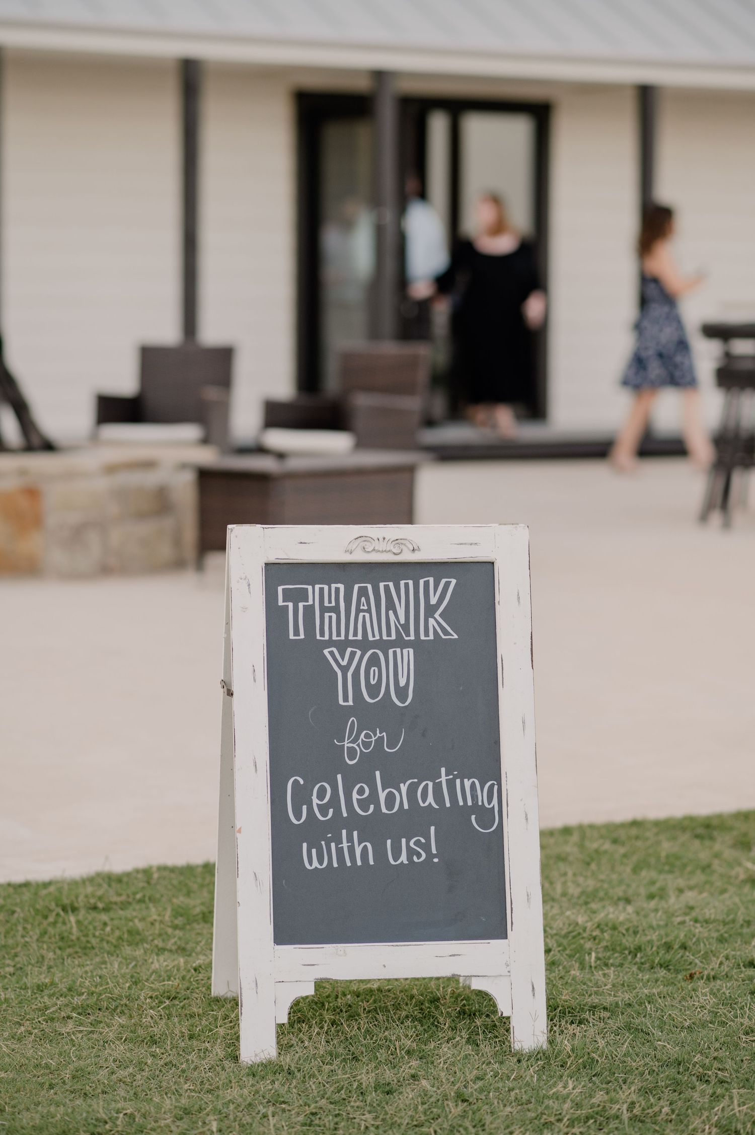 White chalkboard sign reading 'Thank you for celebrating with us' displayed on lawn.