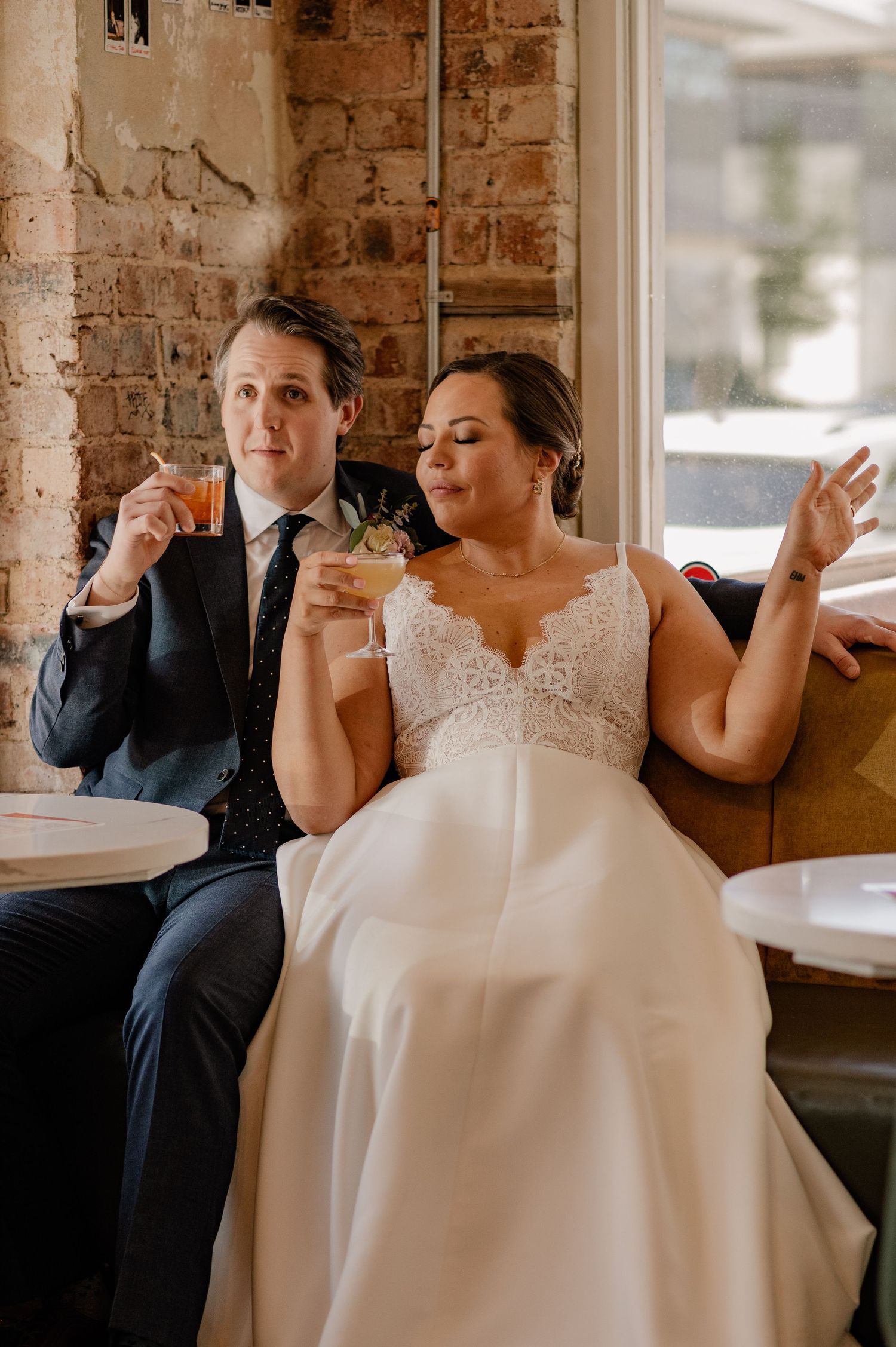 Wedding couple sharing cocktails and laughing at a cafe table in Bishop Arts bar in Dallas, TX