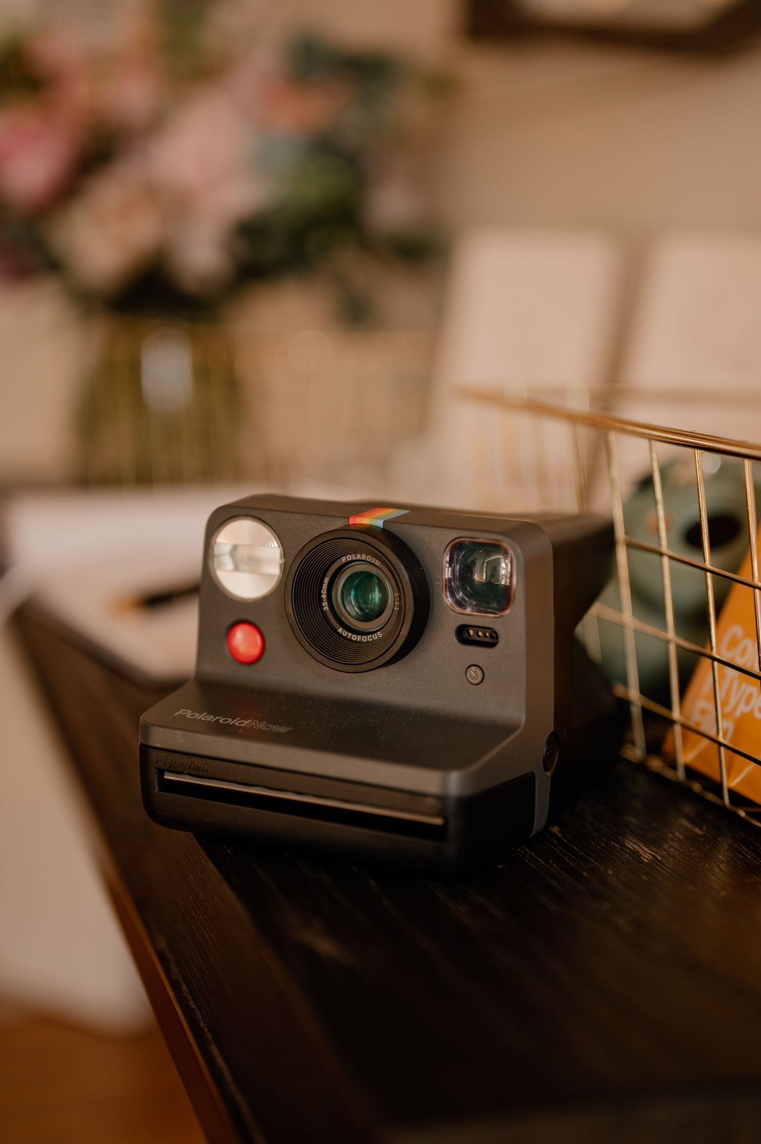 Vintage-style Polaroid camera displayed on dark wooden surface.
