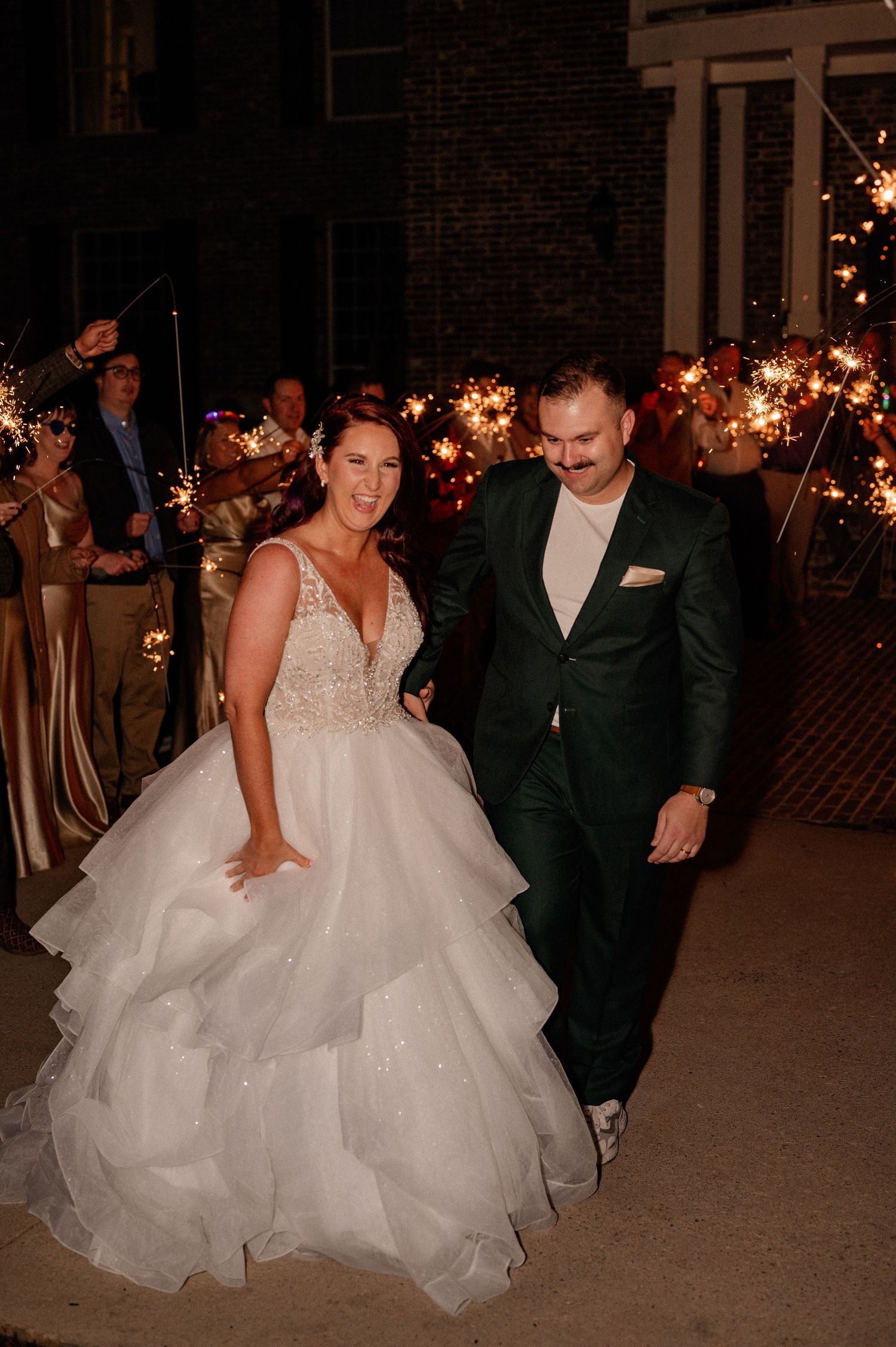 Bride and groom excitedly exit their New Year's wedding reception with a lively grand sparkler exit in Denton, Texas