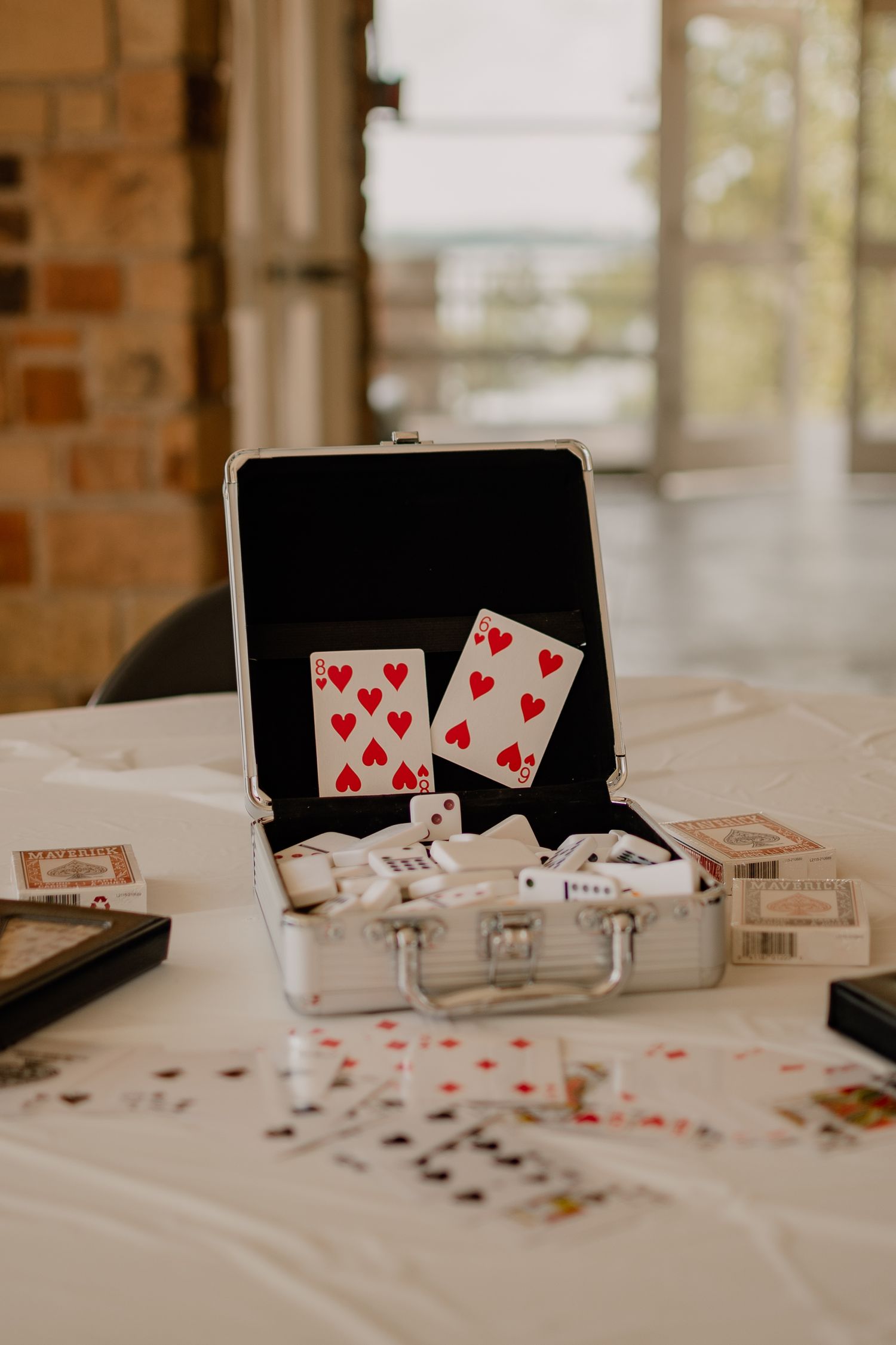 Playing cards and poker chips displayed in an open case on a white tablecloth.