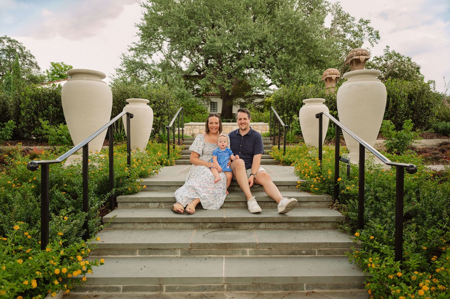 Family posing on steps for a summer family session at the Dallas Arboretum