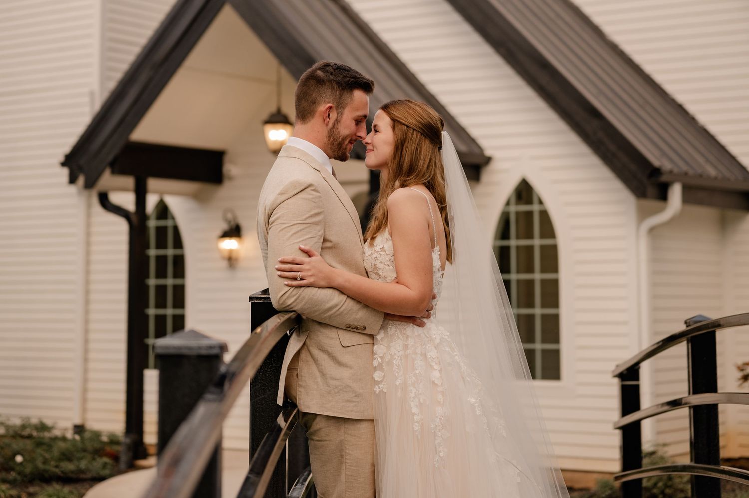 Candid photo of a bride and groom during wedding couple portrait photos outside of a chapel venue in Paradise, Texas
