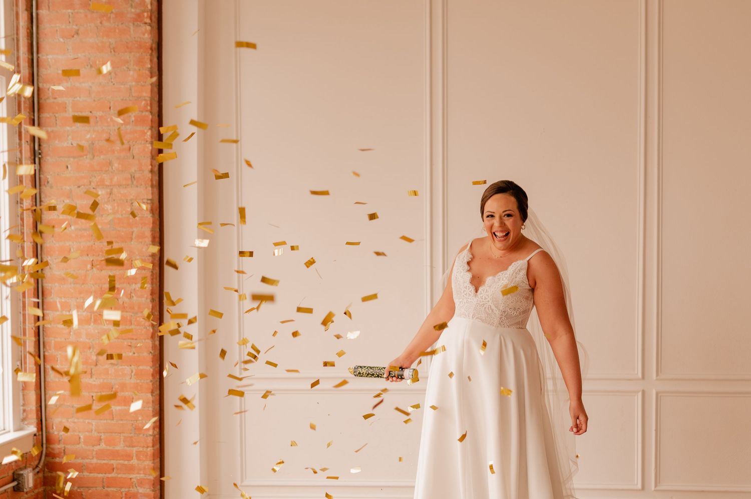 White-gowned figure twirls joyfully in a bright room with golden confetti falling through the air.