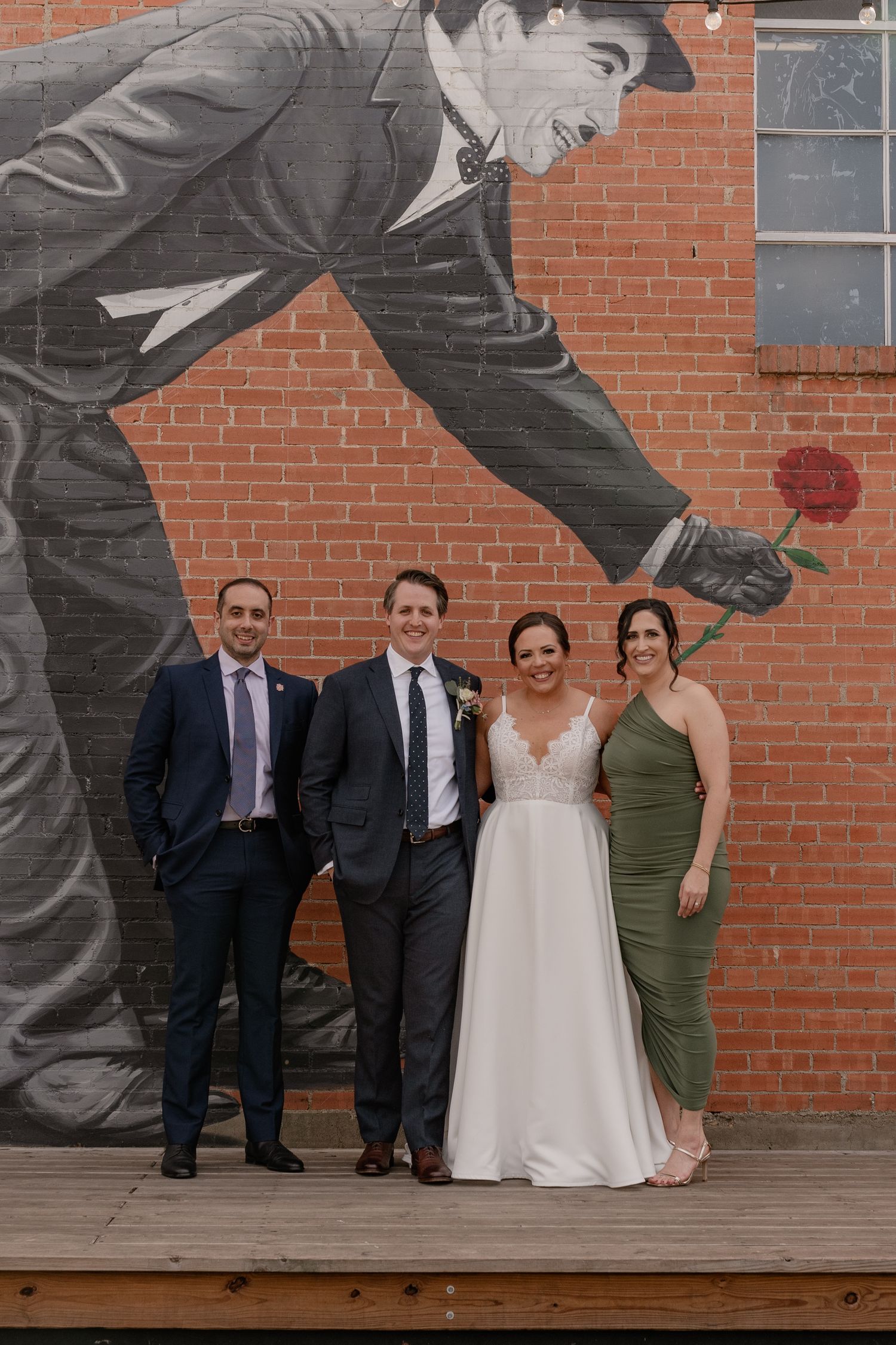 Wedding couple and friends pose together in front of a large mural outside of Bishop Arts area in Dallas, Texas