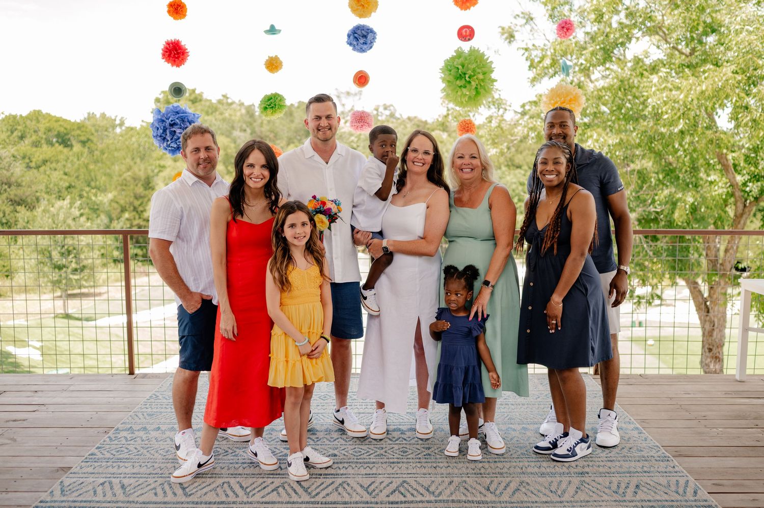 Wedding couple and extended family and friends after an outdoor summer wedding ceremony, during family portraits, in McKinney, Texas