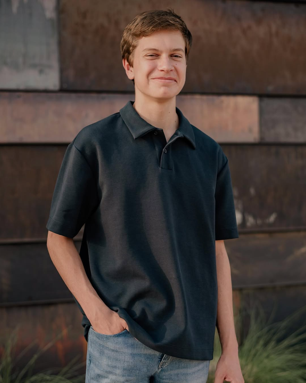 Senior boy standing in front of an urban metal wall for a senior portrait session at University of TX at Dallas in Richardson, TX