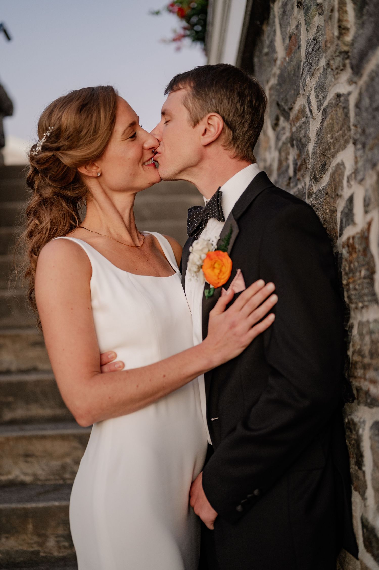 Documentary style candid of a bride and groom kissing during the wedding portraits over looking the lake in the Berkshires Massachusetts