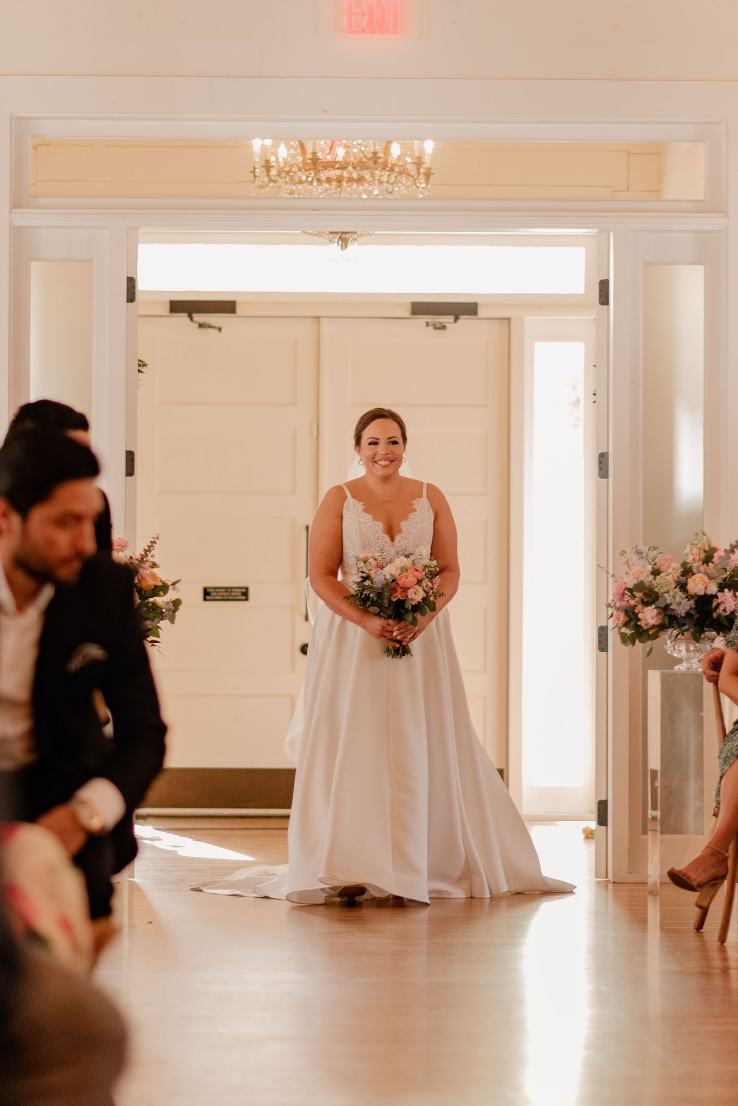 Bride walking down the aisle of vintage white chapel for her spring wedding ceremony at historic Bishop Arts venue in Dallas, Texas