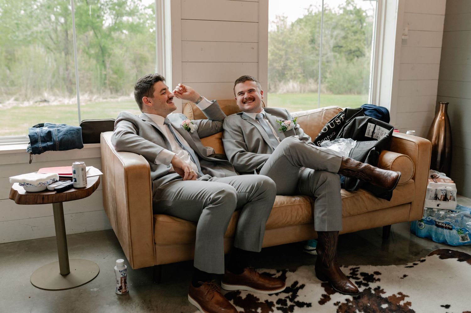 Groomsmen hanging out in a groom's suite while getting ready for a wedding ceremony in Paradise, Texas.