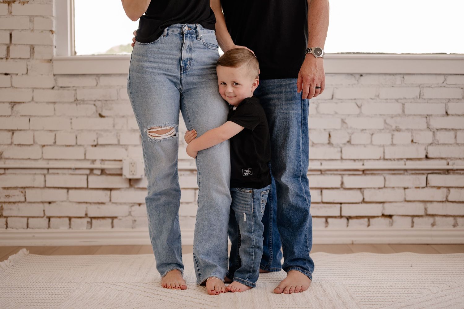 Candid lifestyle photo showing affectionate embraces in a bright indoor studio in Dallas, Texas