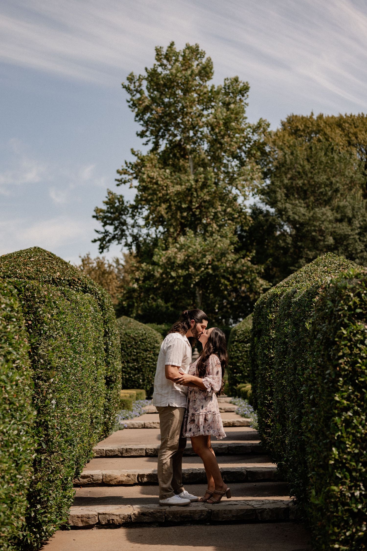 Couple joyfully embracing and laughing during a proposal couple's session at the Dallas Arboretum in East Dallas