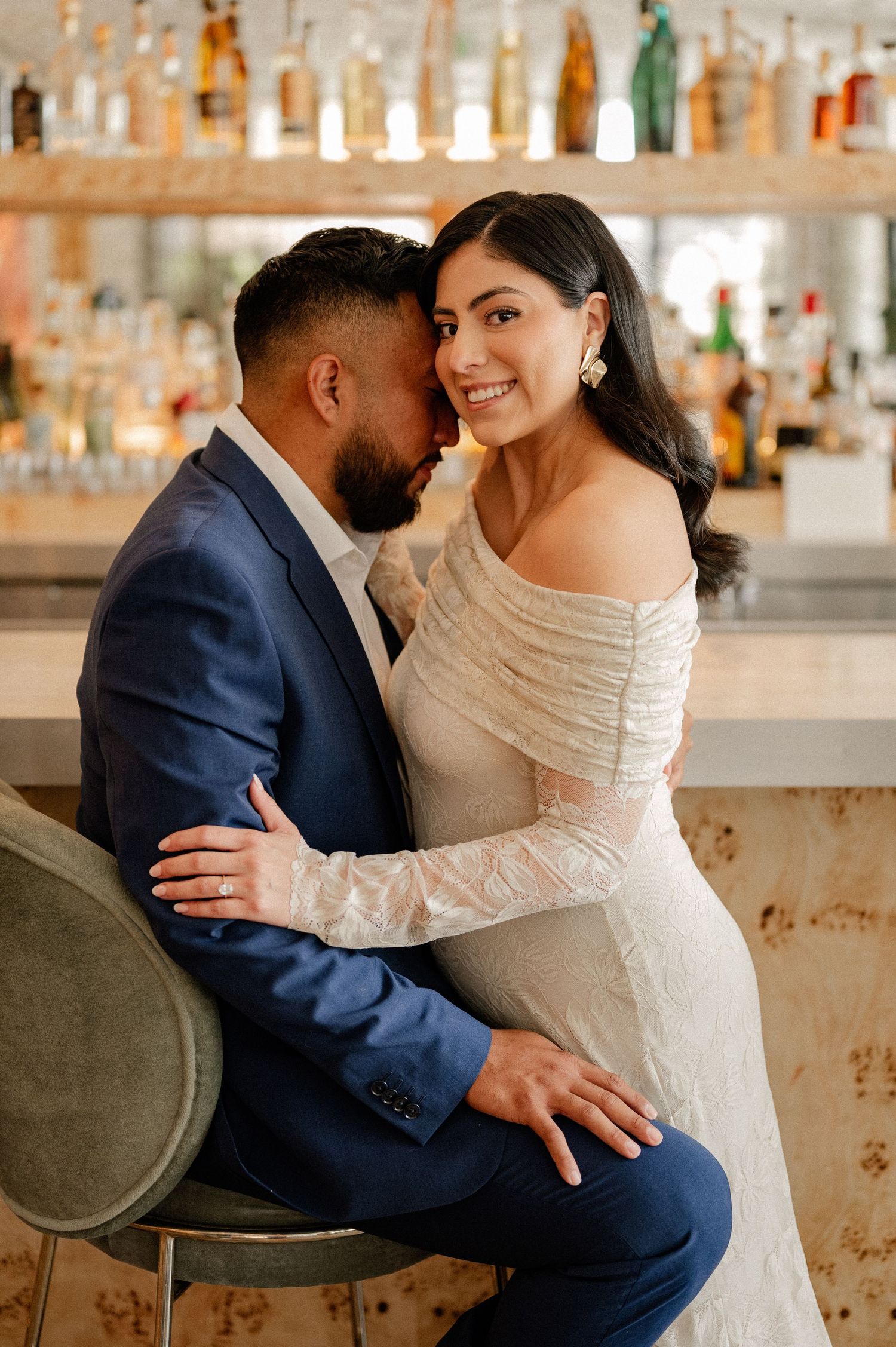 Close up image of couple sweetly embracing during engagement session on a rooftop venue in downtown dallas in front of large upscale bar