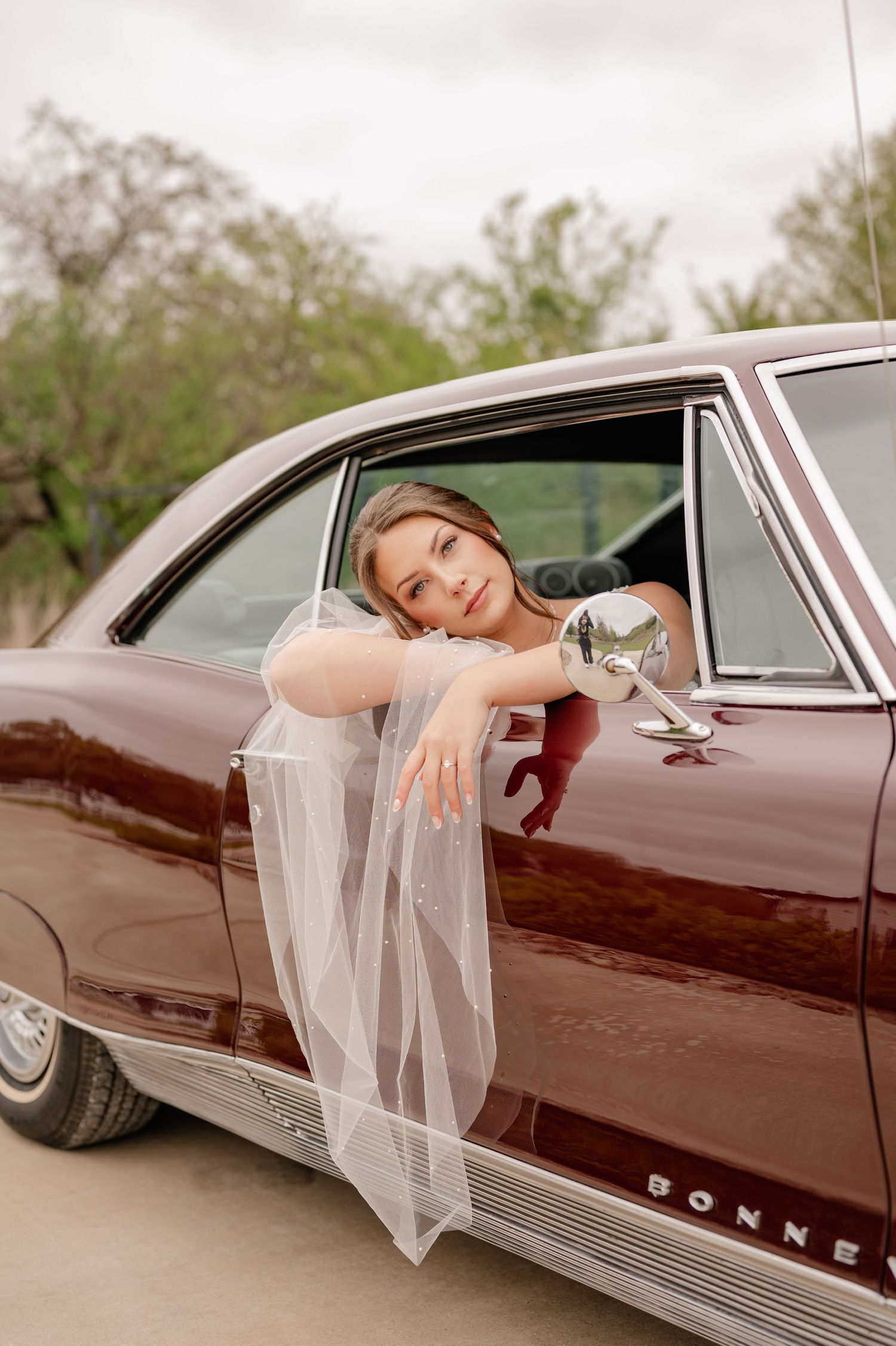Romantically posed bridal portrait of a bride in a classic car during wedding portraits at venue in Fort Worth, Texas
