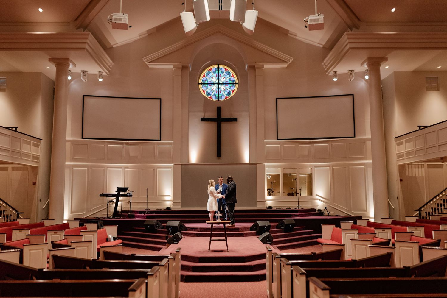 Romantic wide-shot photo of Bride and Groom having a private elopement wedding ceremony in a moody empty church in Dallas, Texas