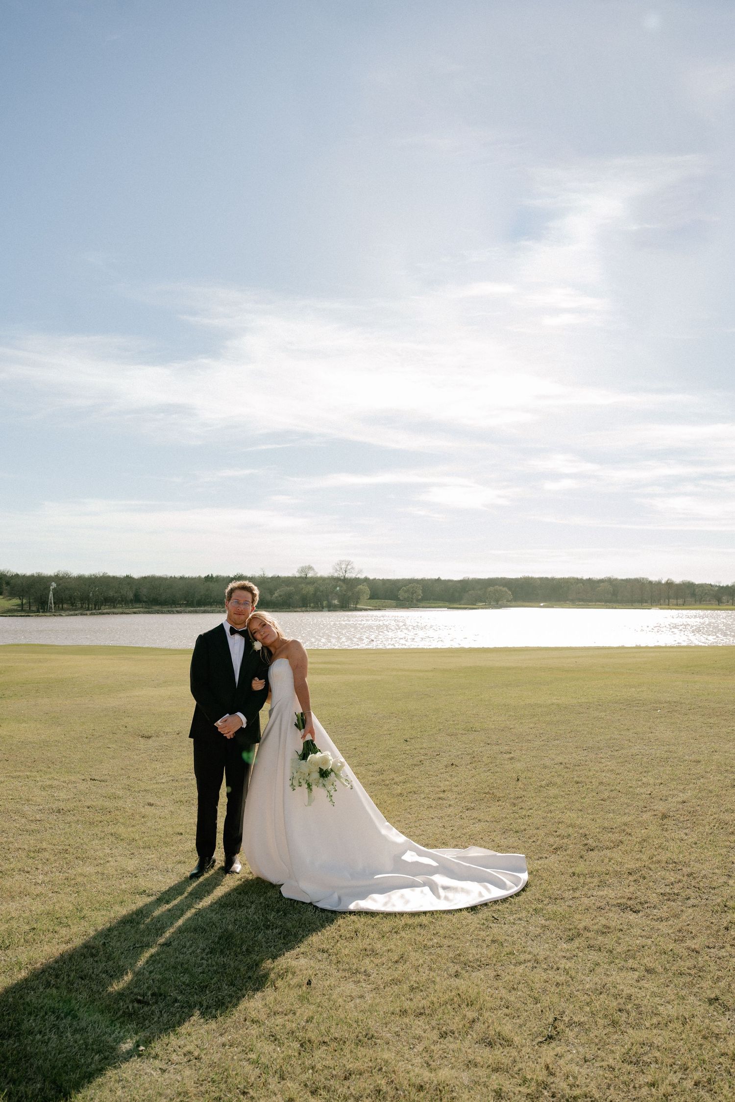 Editorial posed photo of bride and groom cuddling during couple portraits at their wedding in Dallas, Texas