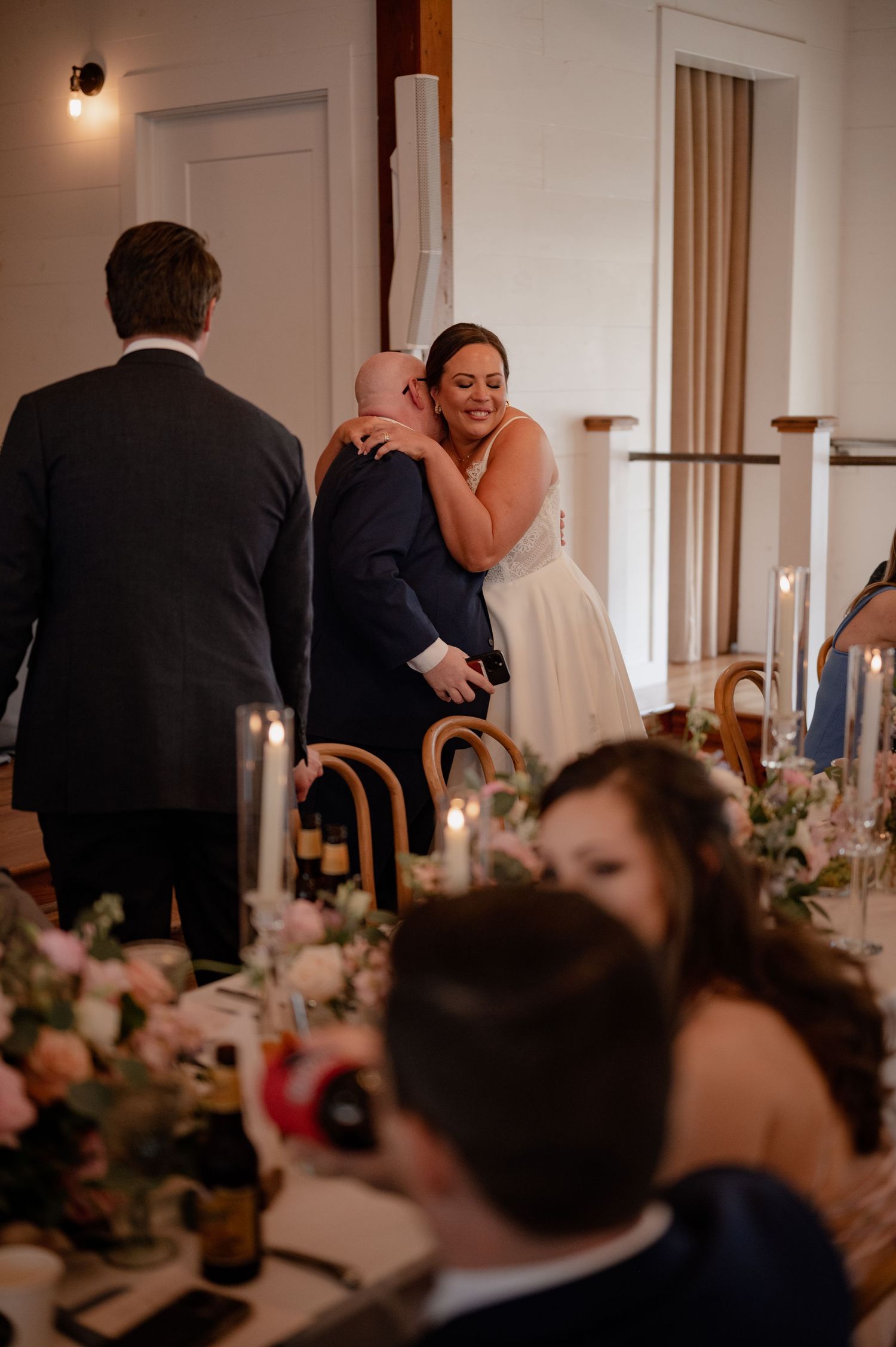 Bride and her brother embrace after heartfelt toast at wedding reception