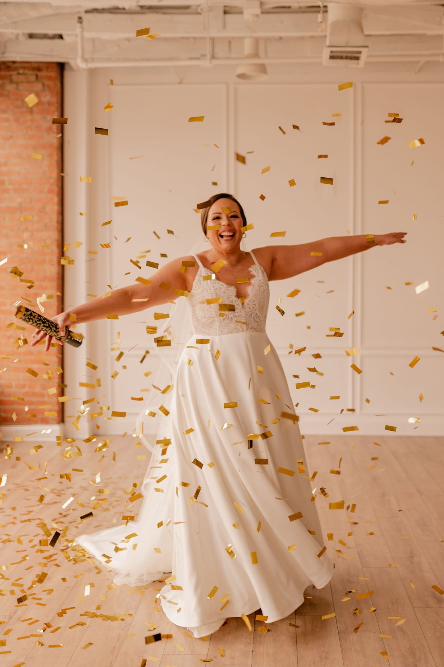 Celebratory dance sequence with gold confetti and flowing white gown in a bright interior space.