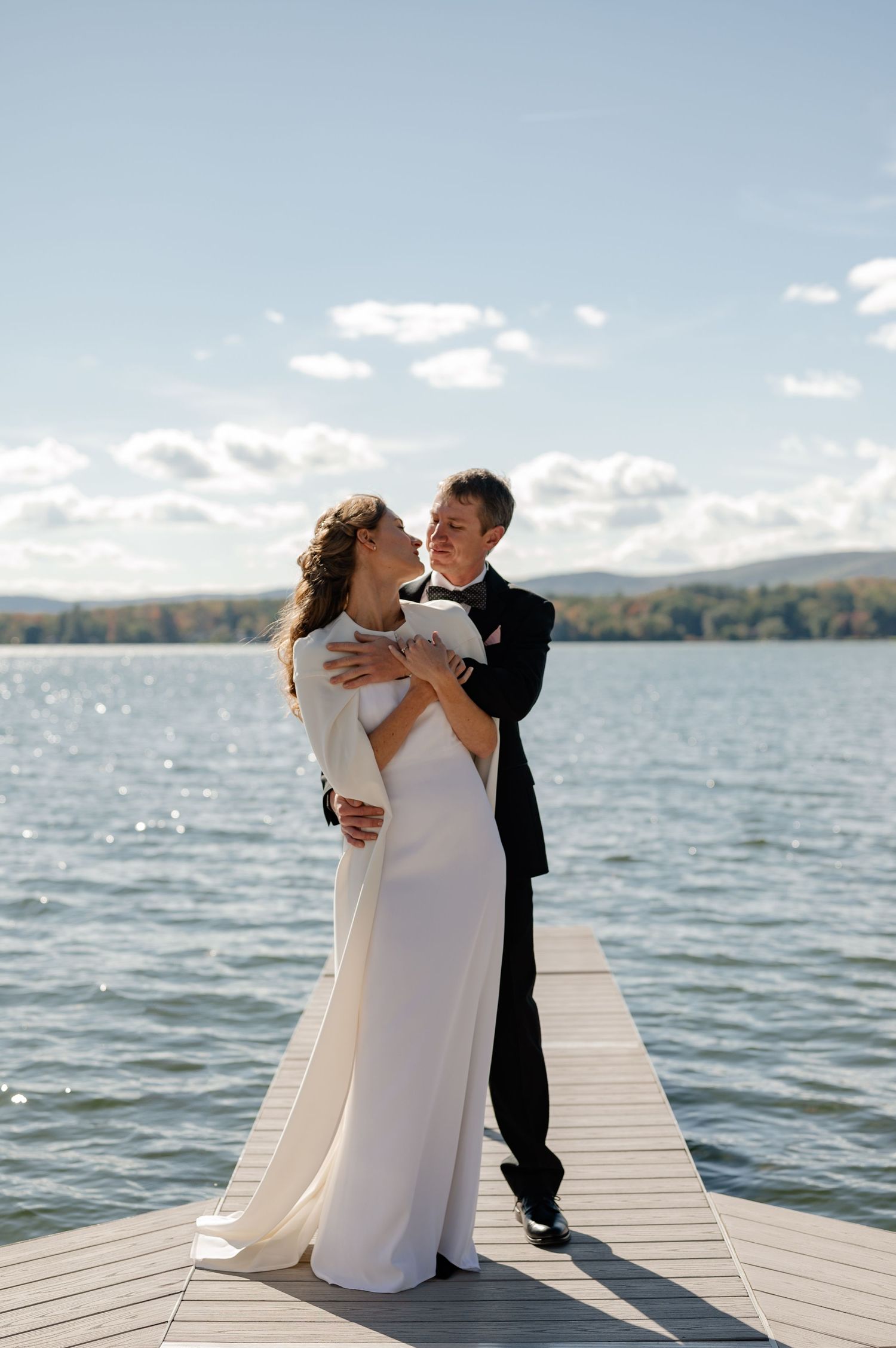 Documentary style candid of a bride and groom during the wedding portraits over looking the lake in the Berkshires Massachusetts