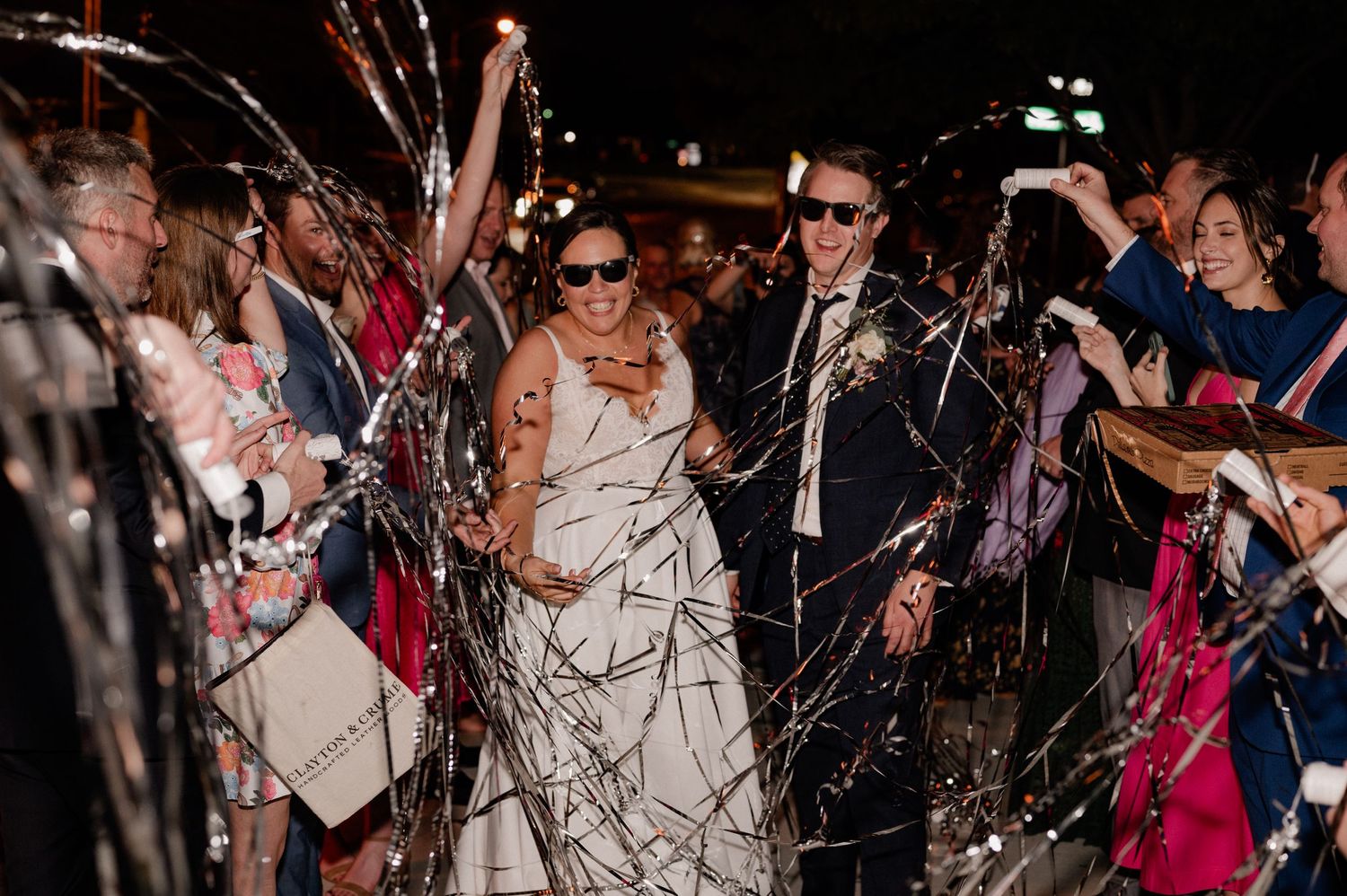 Guests line pathway with streamers as wedding couple makes their grand exit of Bishop Arts venue in Dallas, Texas