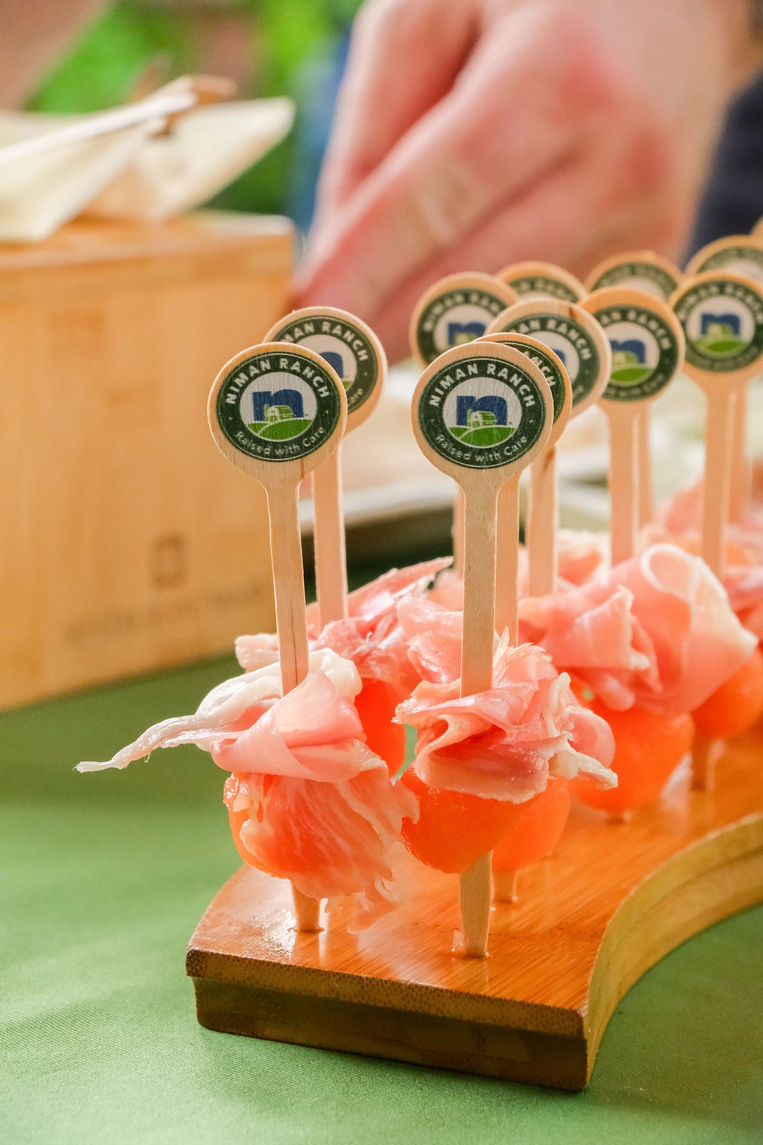Elegant charcuterie appetizers on toothpicks with Hilmar Ranch labels displayed on a wooden serving board.