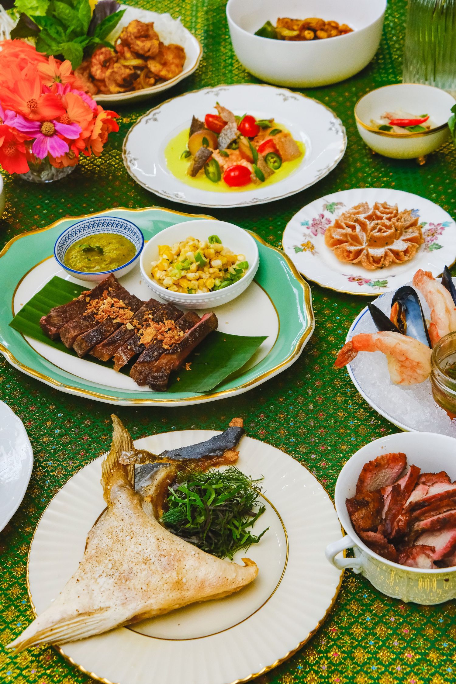 Traditional Chinese banquet table spread with roasted meats, seafood, and side dishes served on white plates.