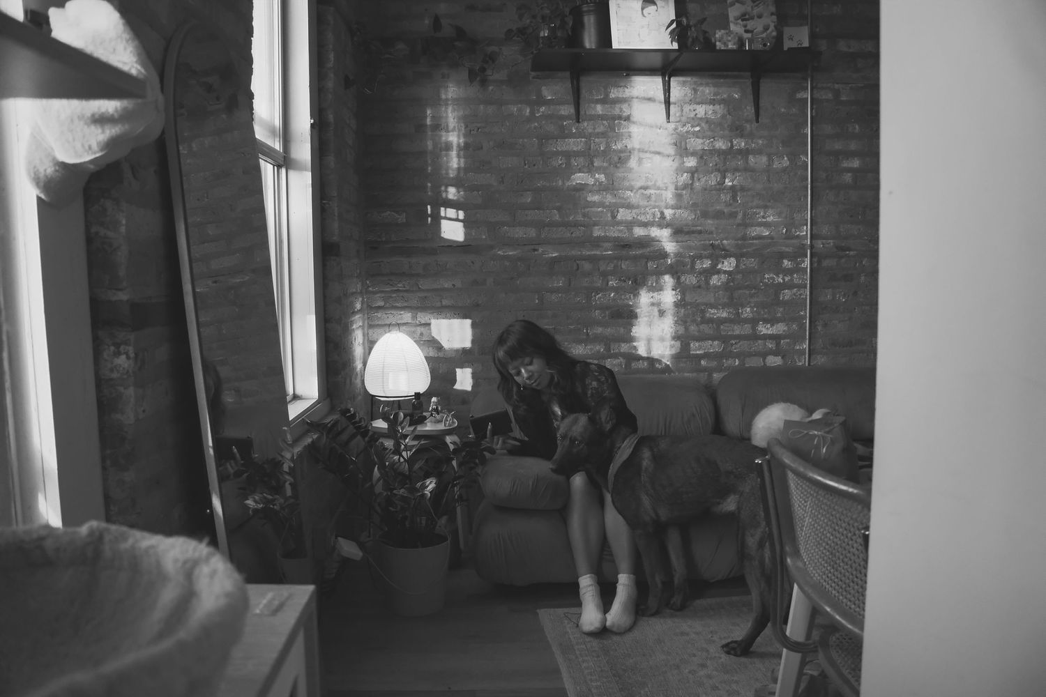A black and white panoramic photo shows a brick warehouse interior with beams and windows illuminating the space.