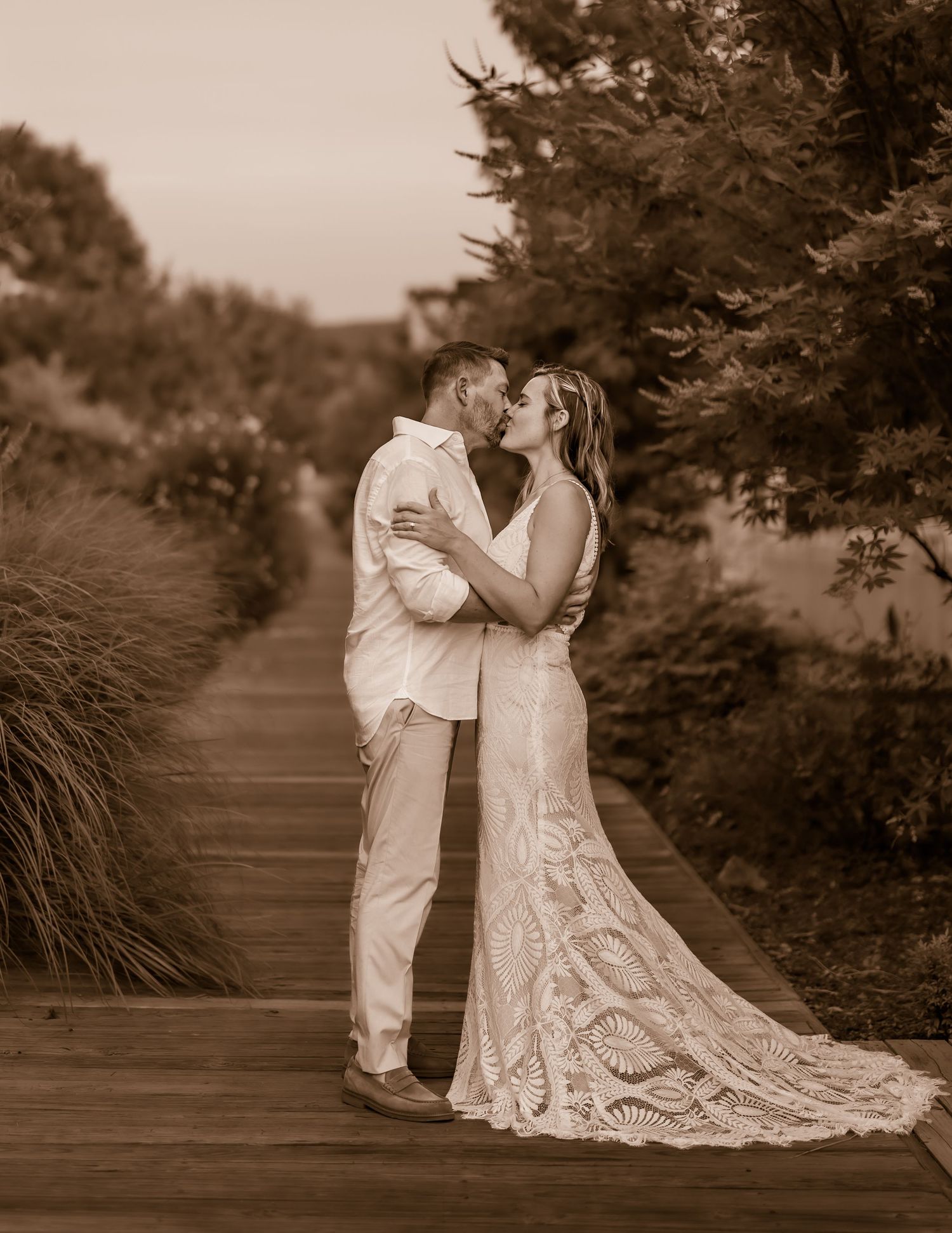 A romantic wedding photoshoot sequence on a garden path shown in sepia tones.