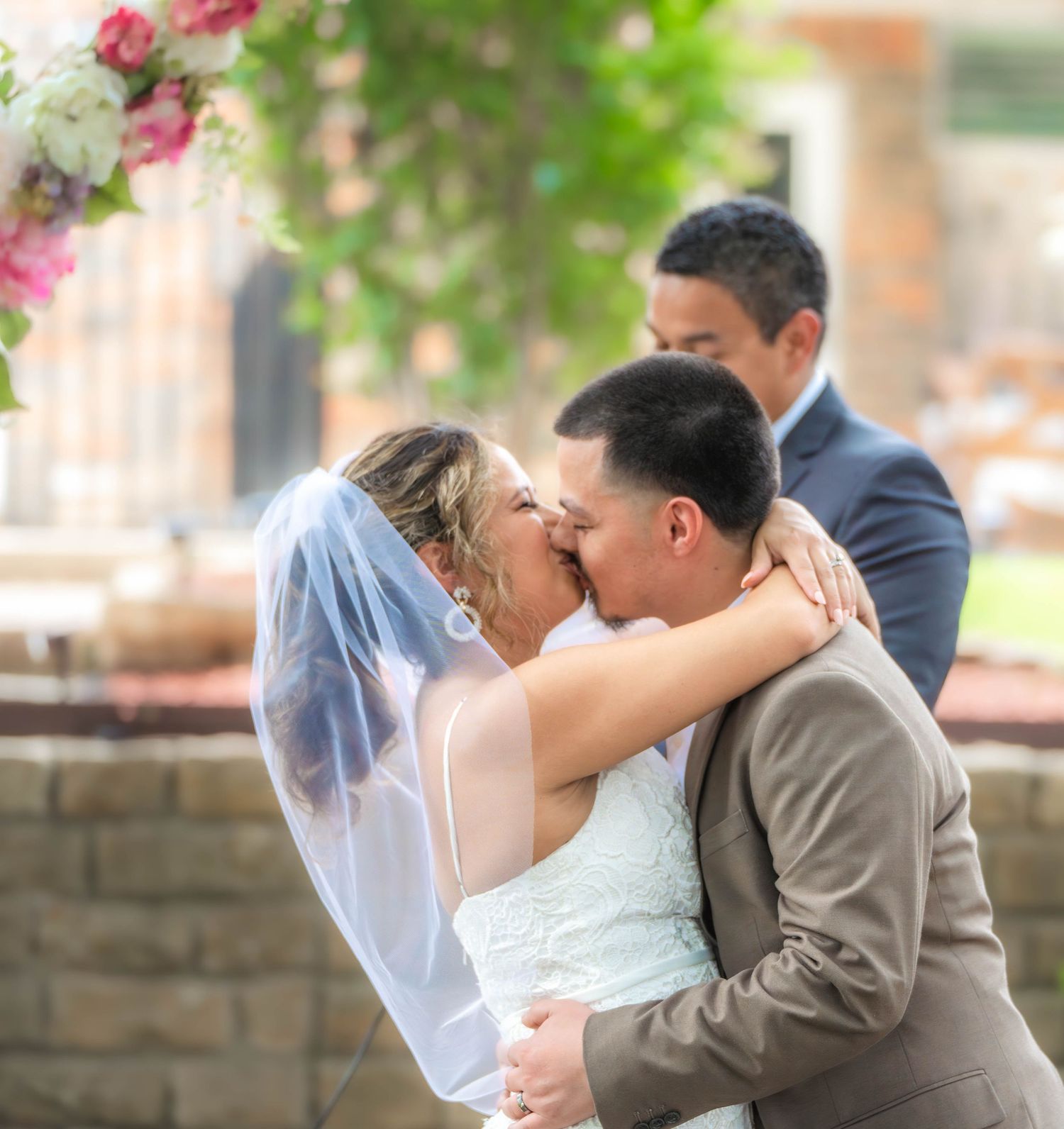 A romantic wedding couple sharing kisses in multiple candid moments against a blurred outdoor backdrop.