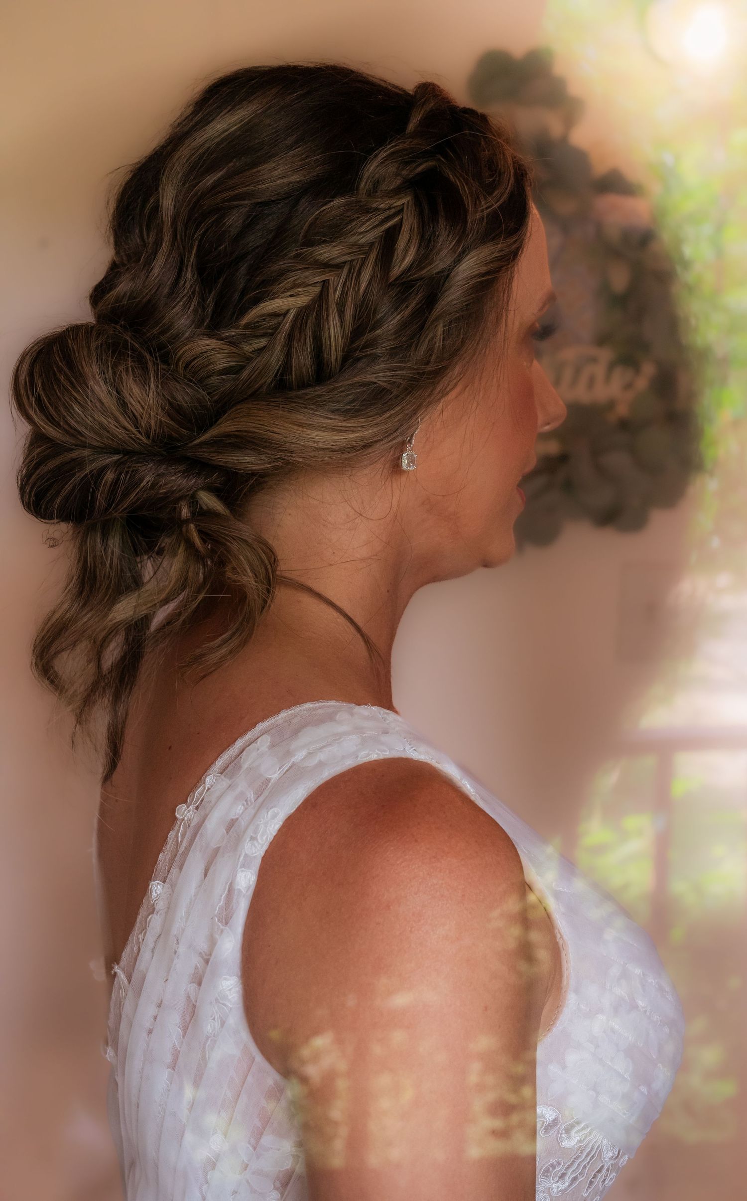 Elegant bridal hairstyle featuring intricate braids and curls captured in profile.