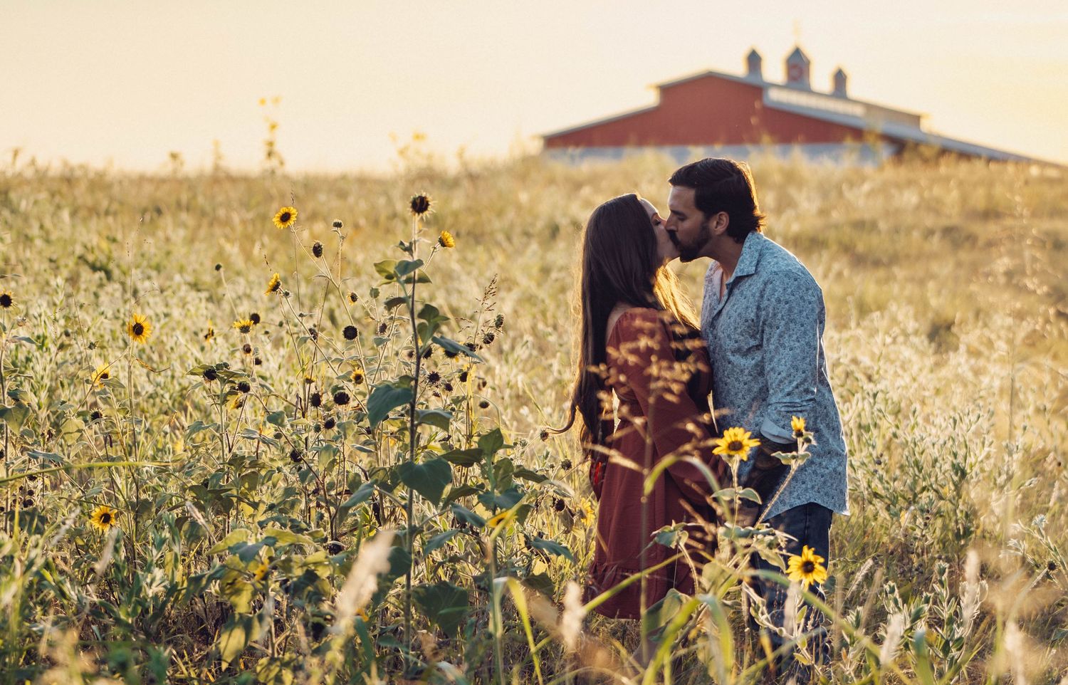 Couple sharing tender moments in a wildflower field during golden hour.