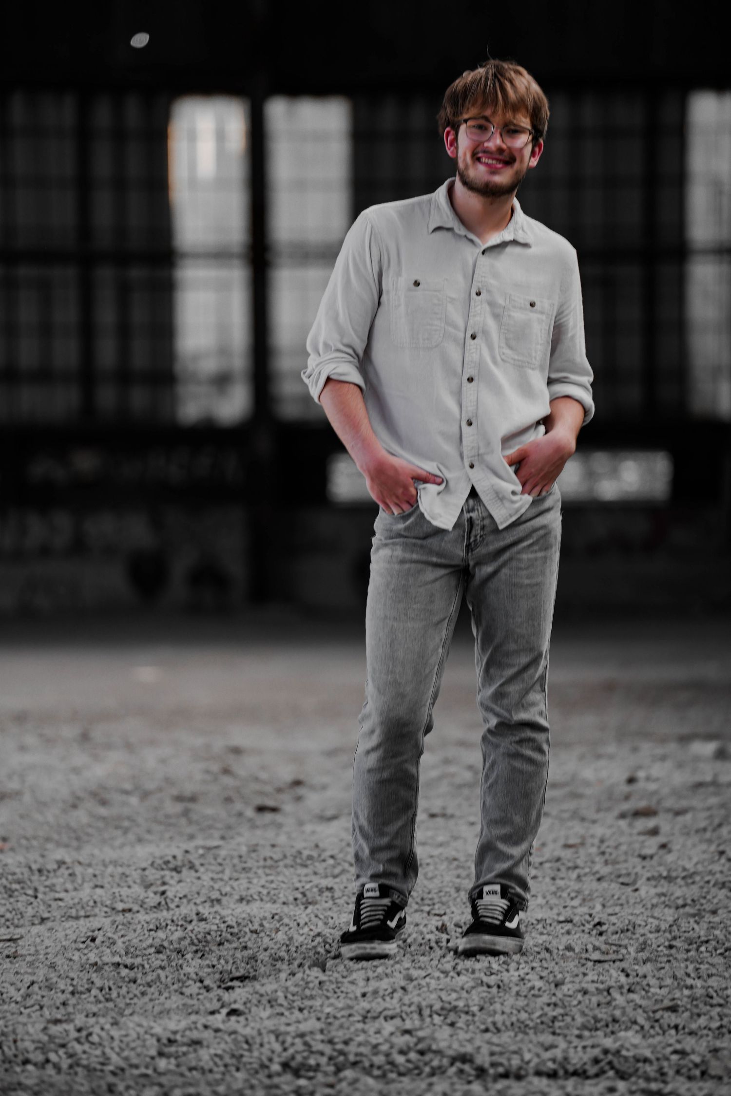 Low angle view showing black sneakers and gray pants on a gritty industrial surface.