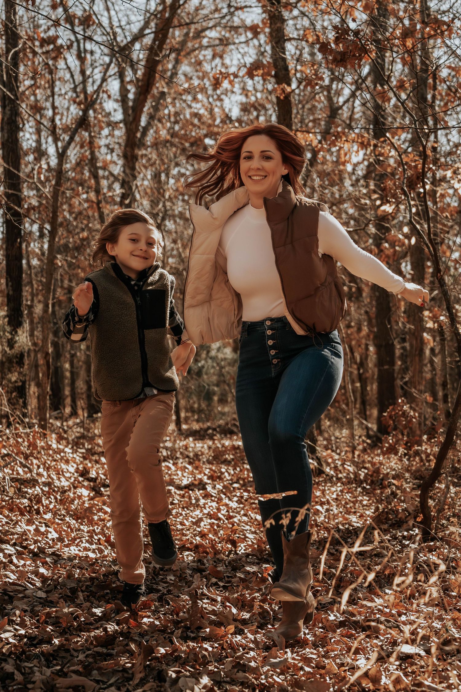 People having fun and skipping in a forest filled with fall foliage.