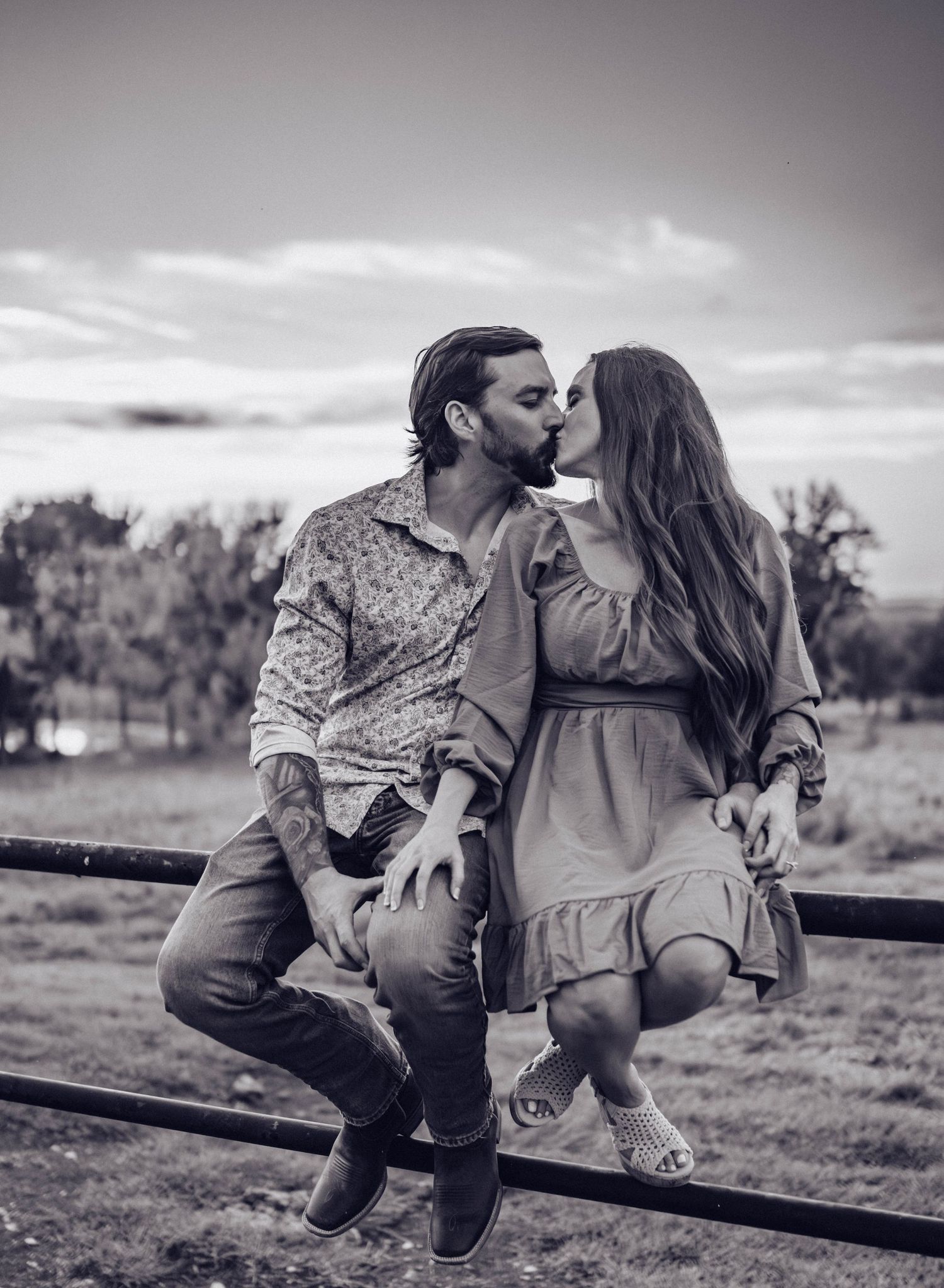 Black and white photos of a couple sharing intimate moments on a wooden fence.