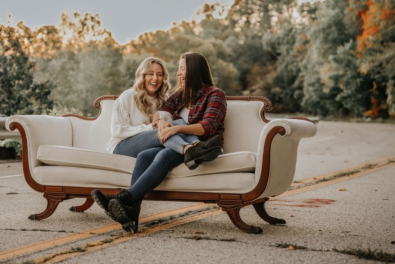 Romantic couples lounging on vintage furniture during an outdoor photo session.