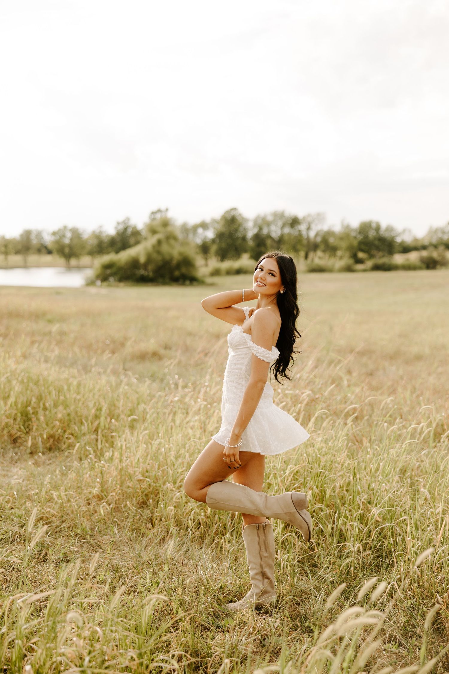 A white dress twirls gracefully in a sunlit meadow during golden hour.