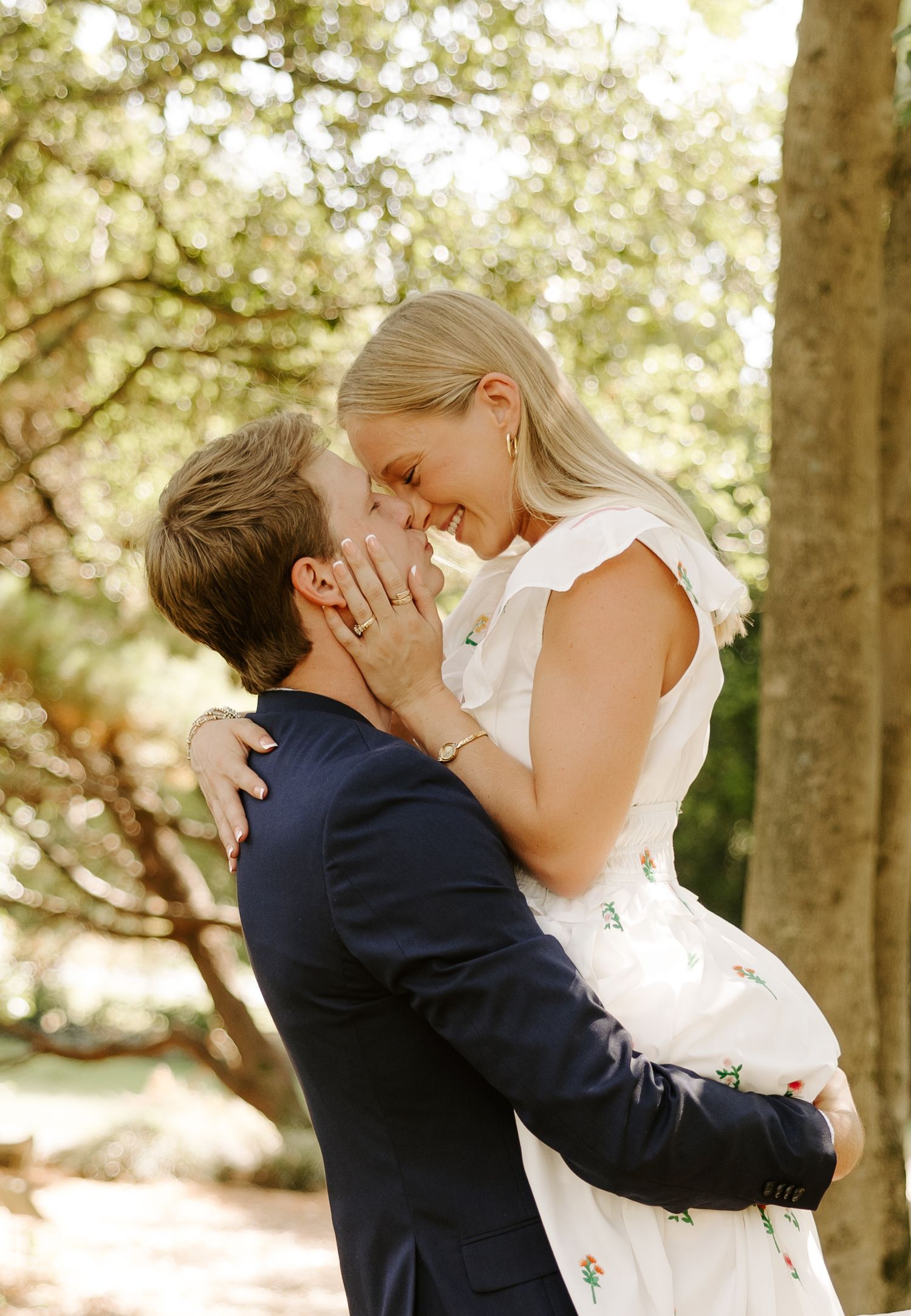 Romantic moment shared between a couple in a wooded outdoor setting.