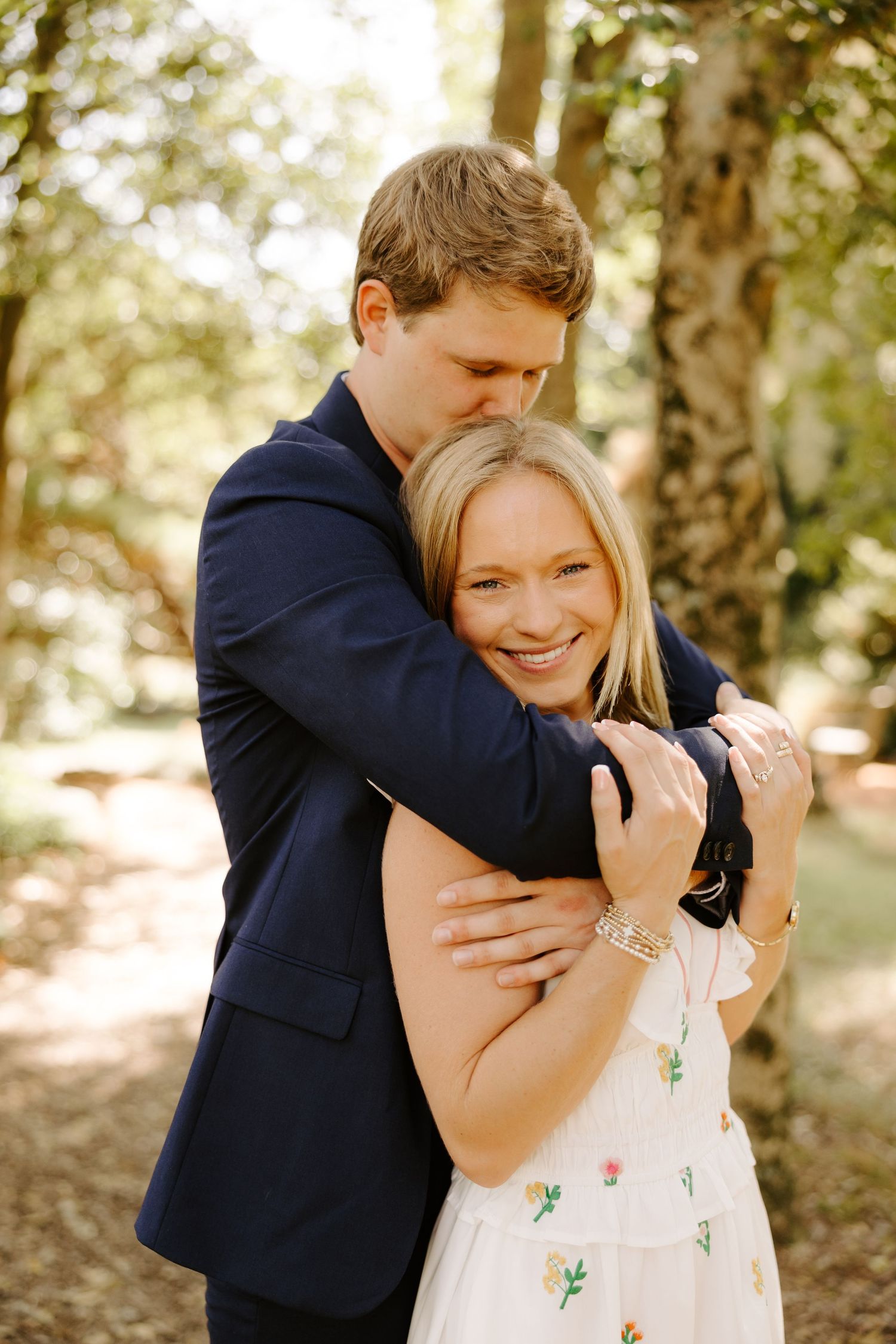 Joyful embrace captured in a series of candid moments in a wooded setting.
