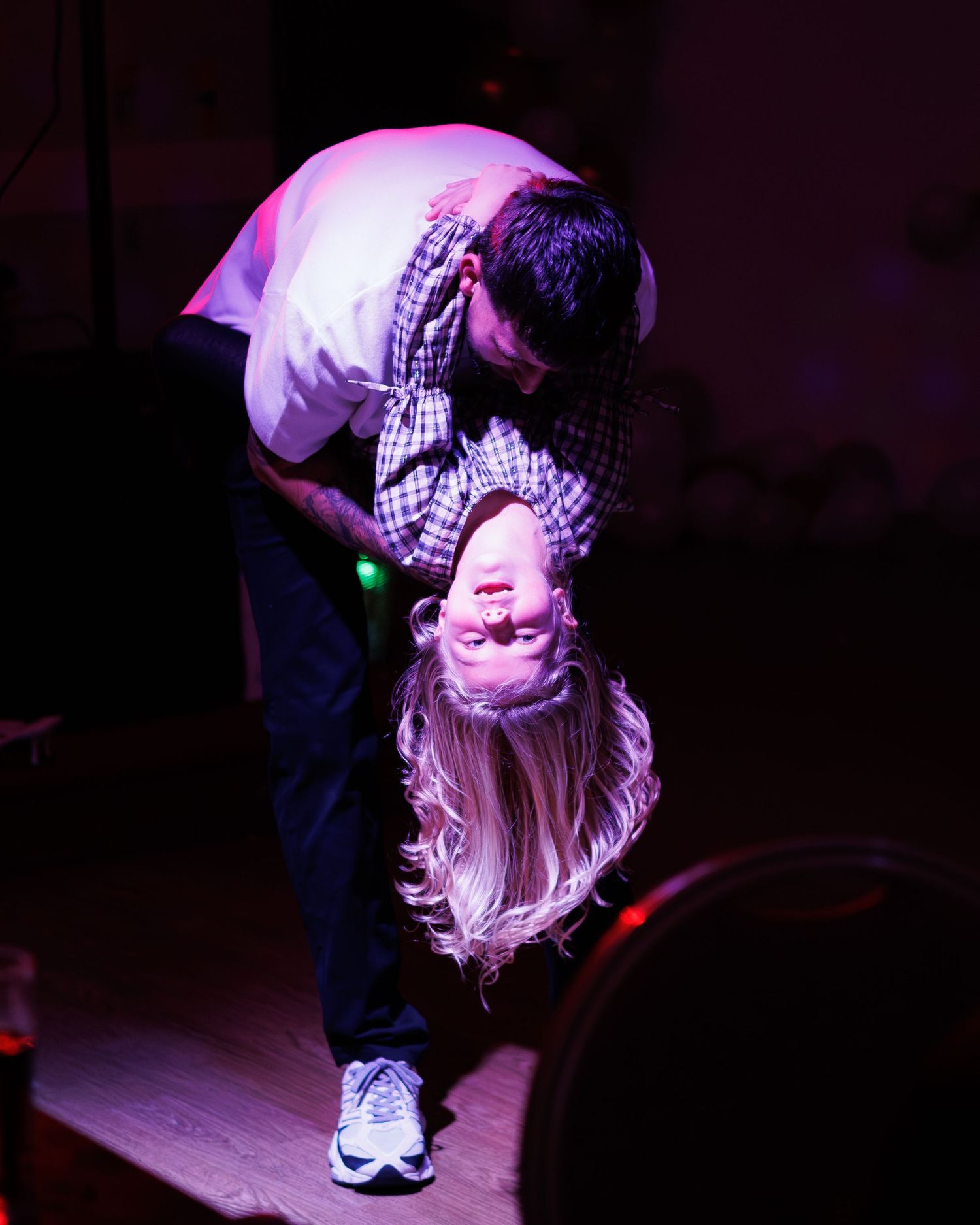 A sequence of dark purple-lit photos showing a person bending forward with long blonde hair.