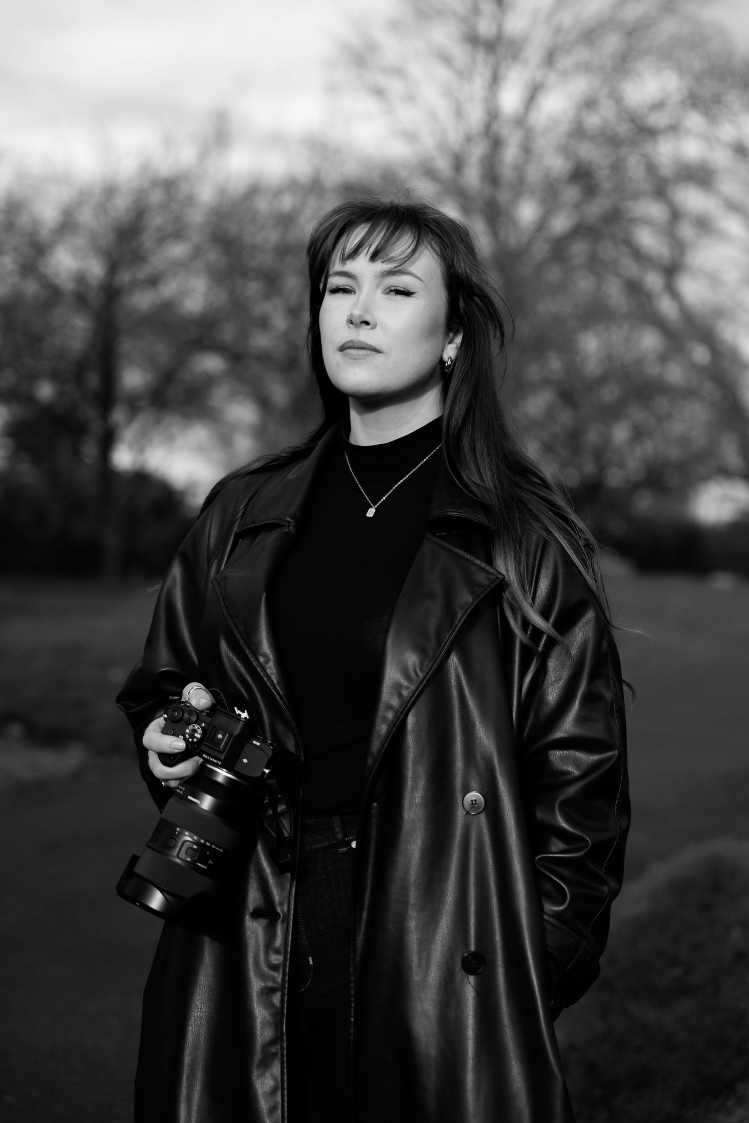Black and white photo series showing a figure in a leather coat and turtleneck holding a camera outdoors.