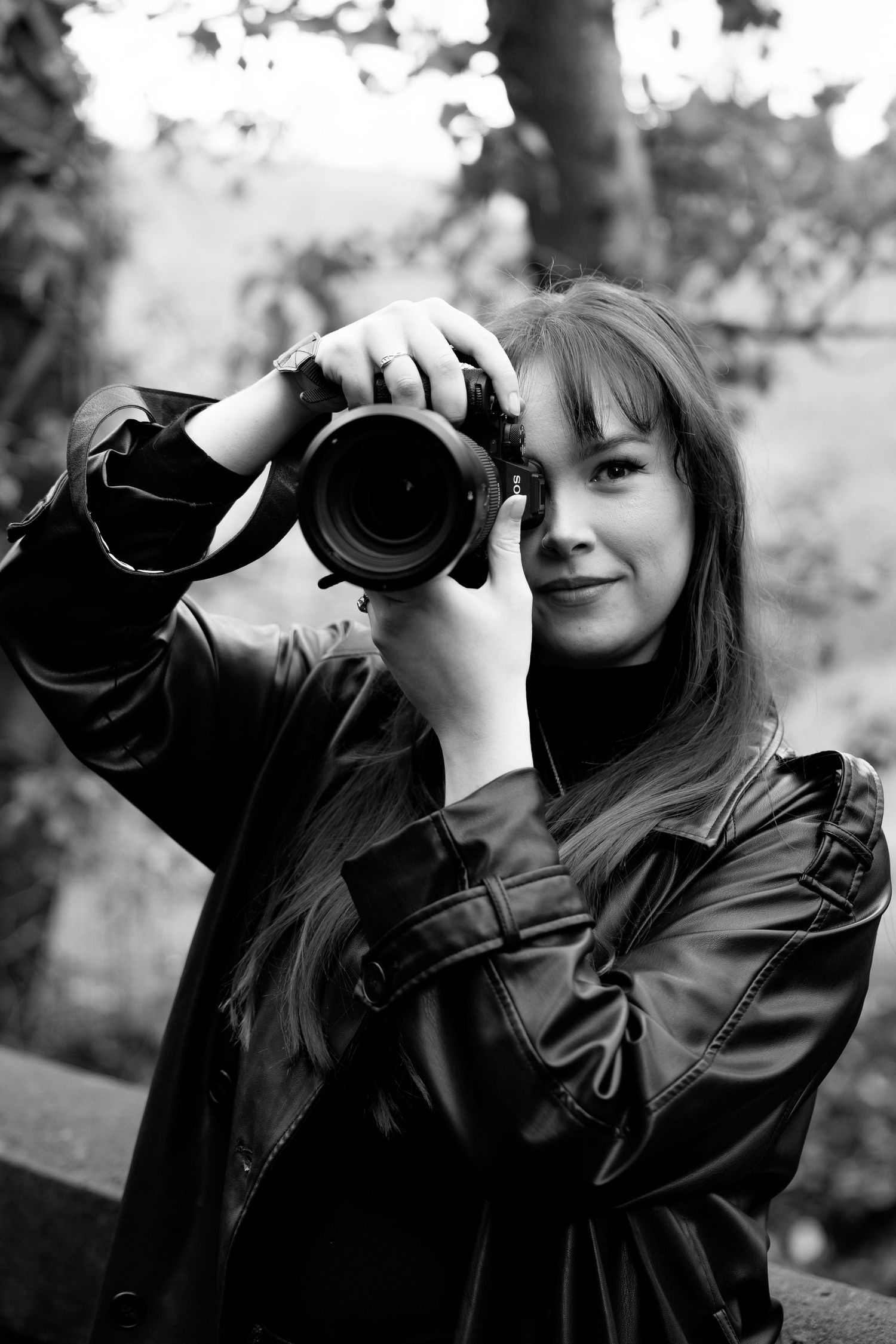 A sequence of five black and white photos showing a photographer taking pictures with a professional camera.