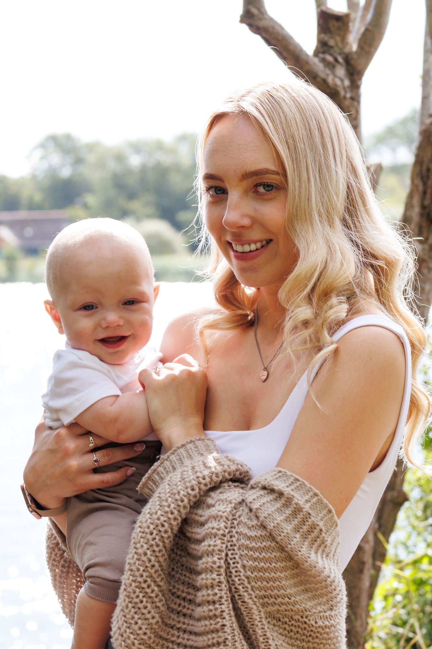 A series of four candid outdoor photos showing joyful moments between a parent and baby in matching beige sweaters.